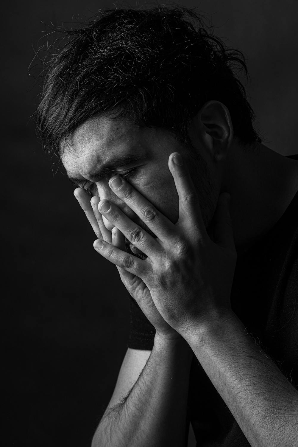 A sad man covering his face | Source: Pexels