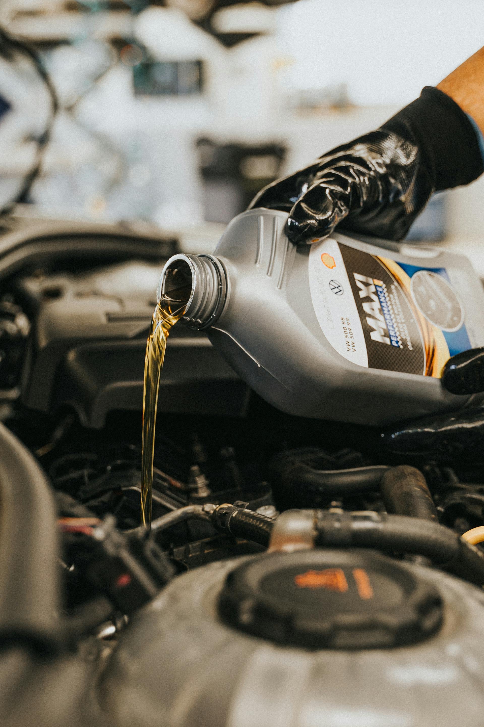 Someone putting oil in a car engine | Source: Pexels