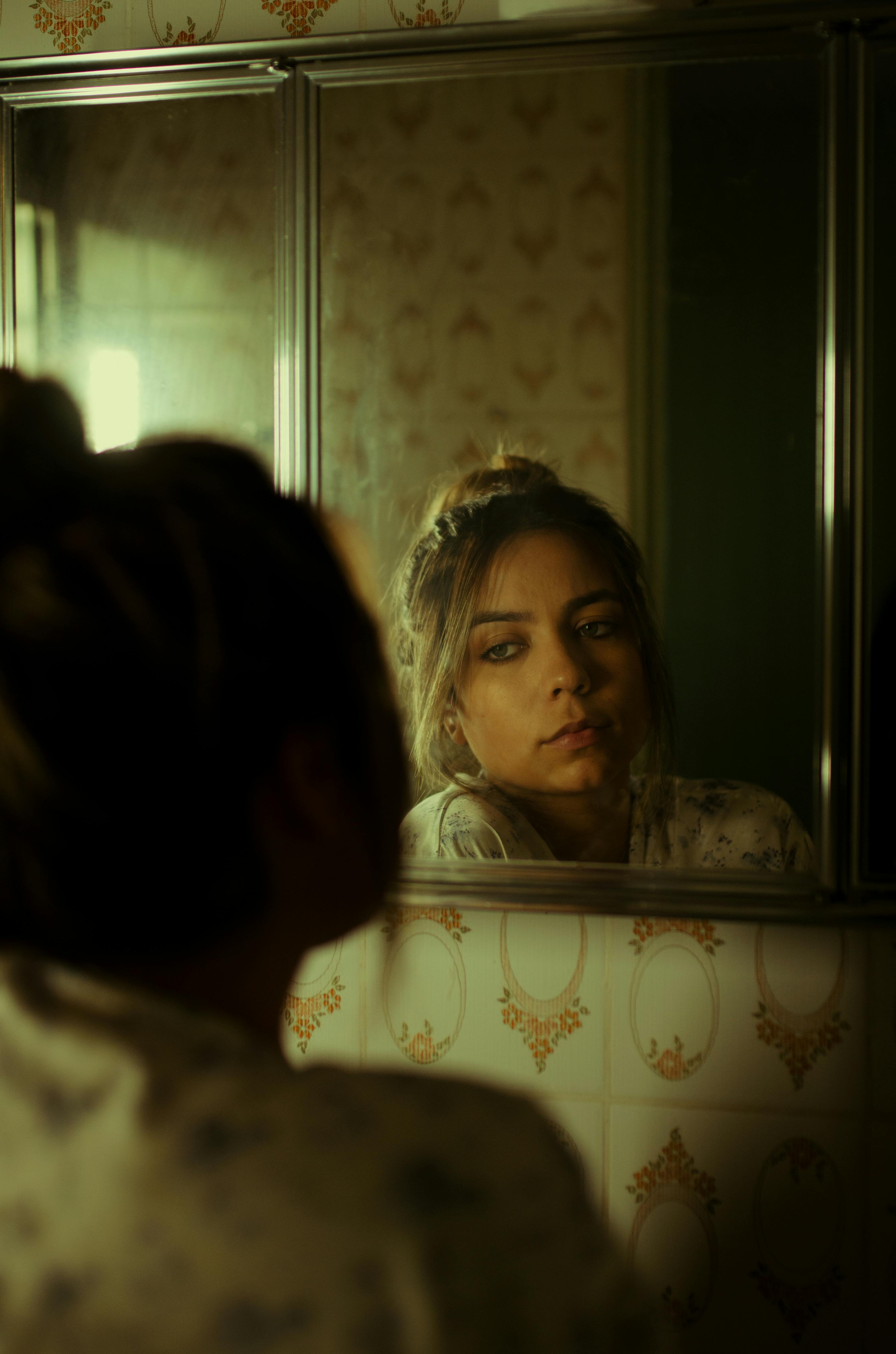 A woman looking at the mirror | Source: Pexels