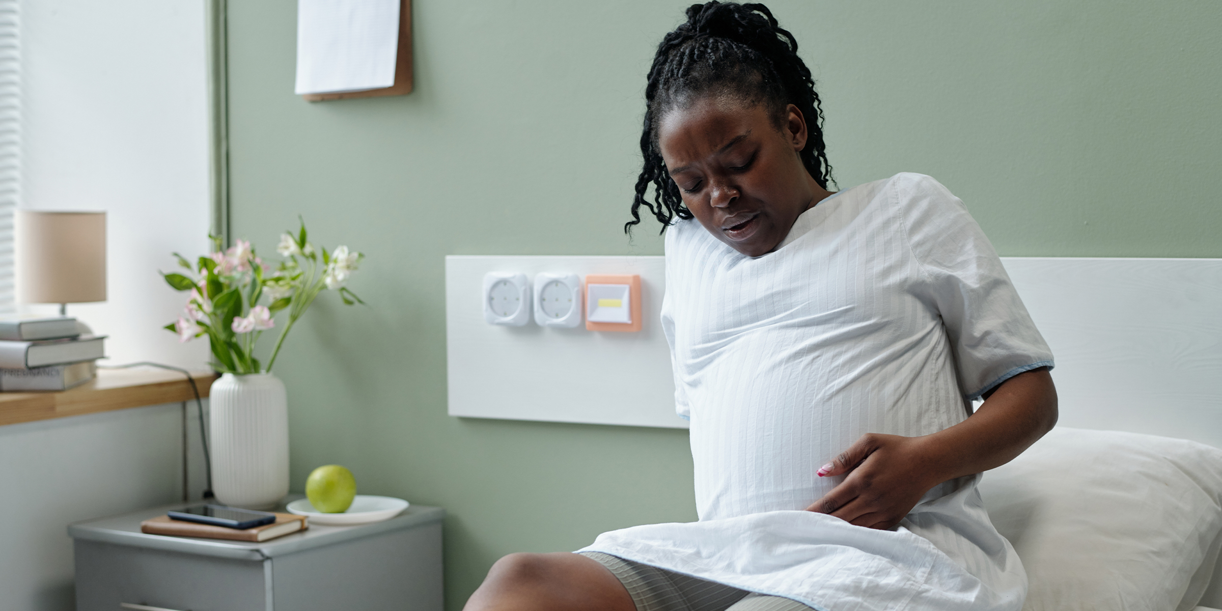 A pregnant woman holding her belly | Source: Shutterstock