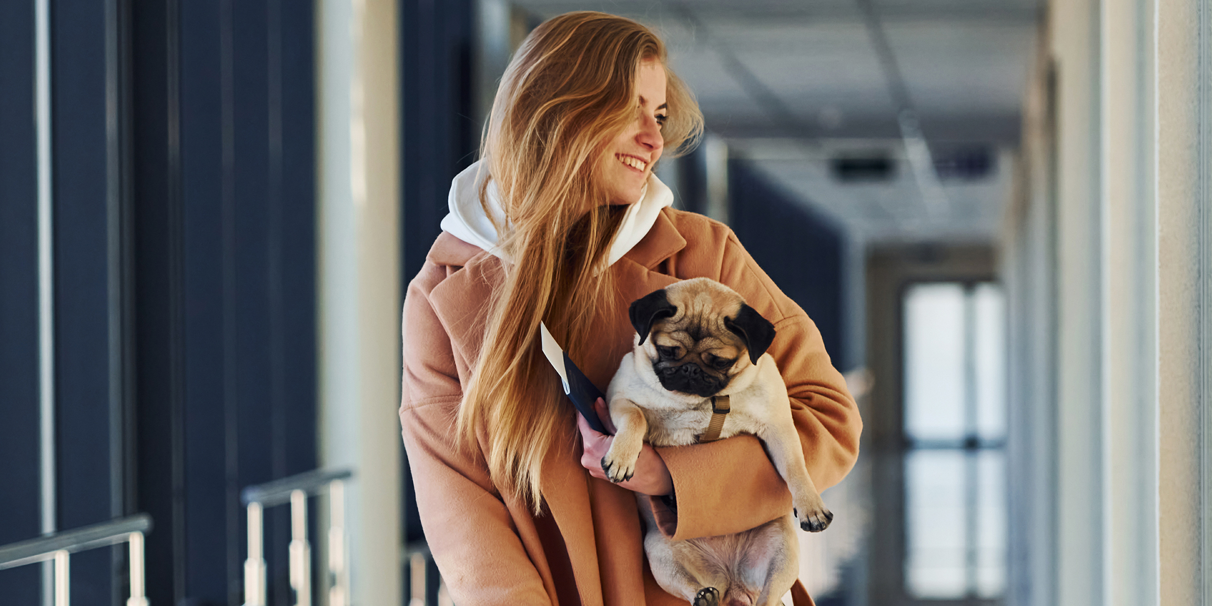 A smiling woman with a small dog | Source: Shutterstock