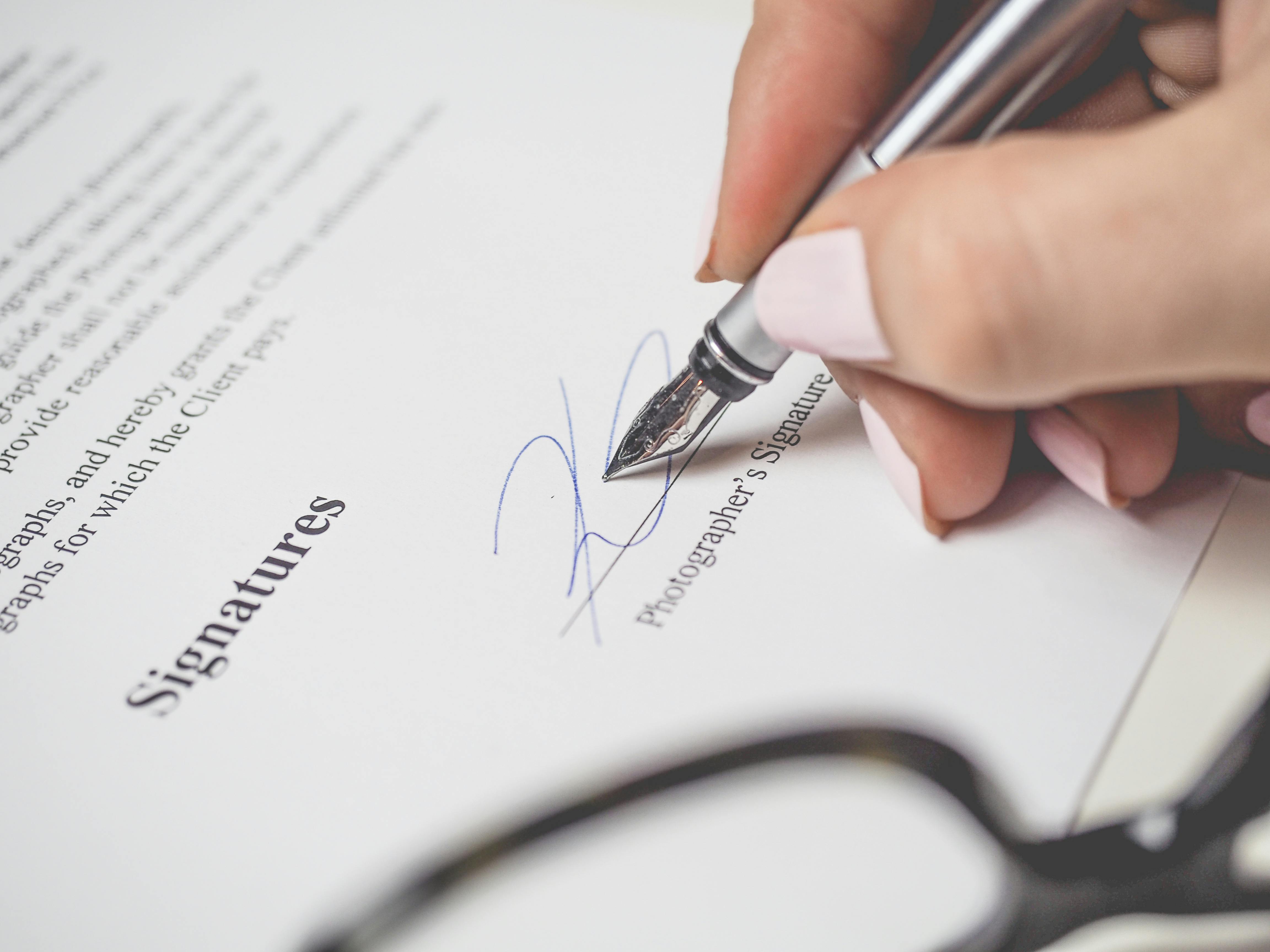 A person signing a document | Source: Pexels