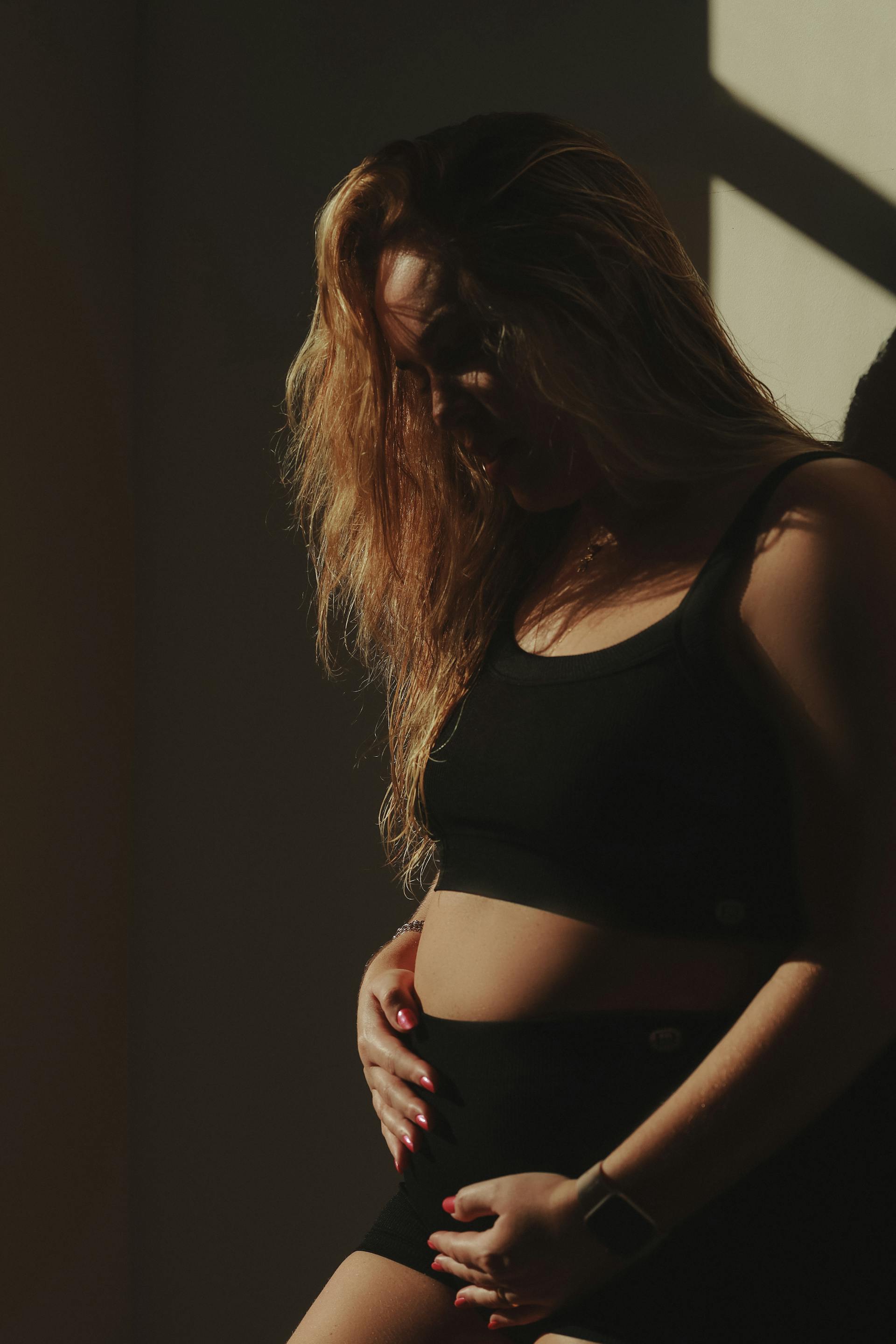 Uma mulher grávida tocando a barriga | Fonte: Pexels