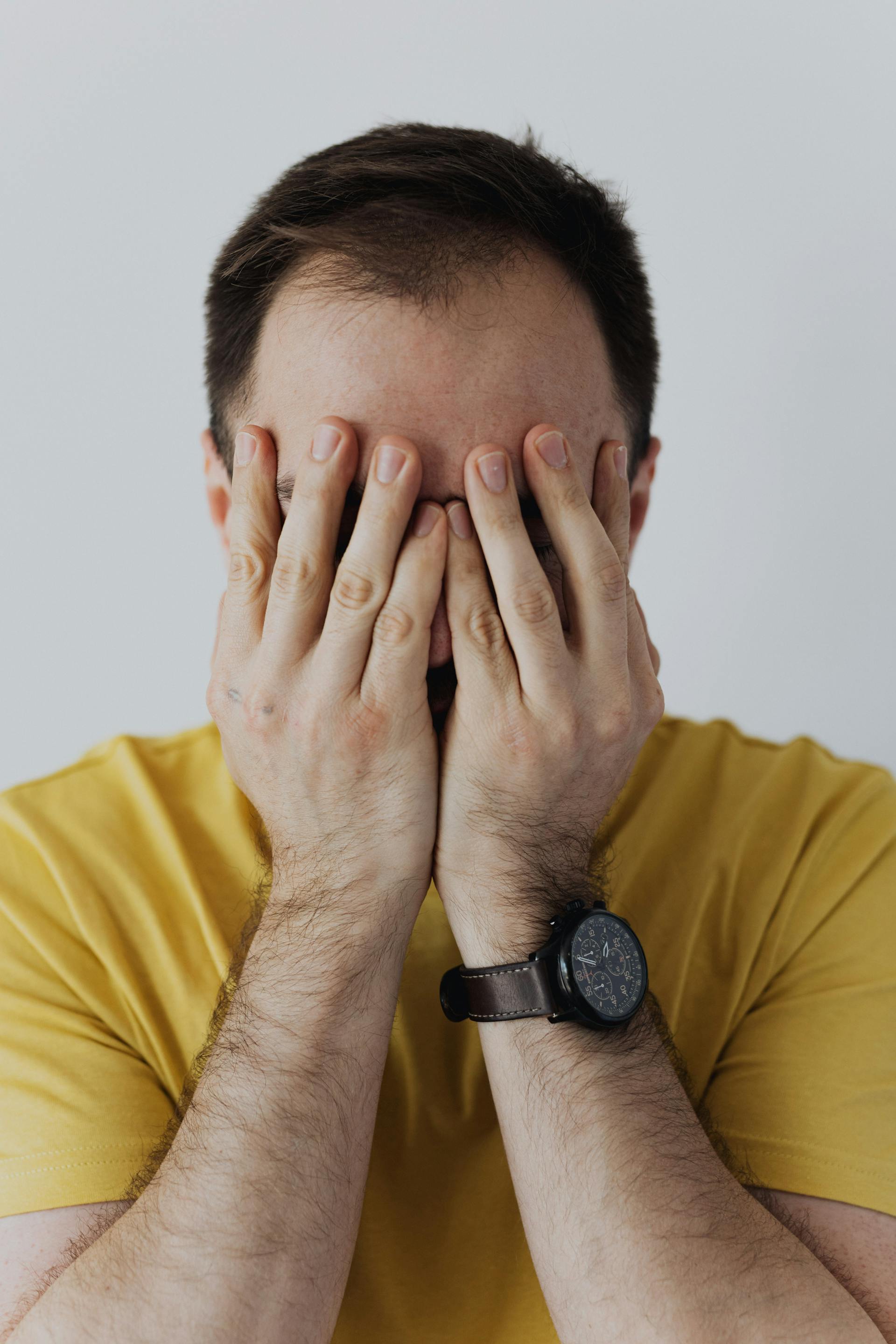 A man covering his face with his hands | Source: Pexels