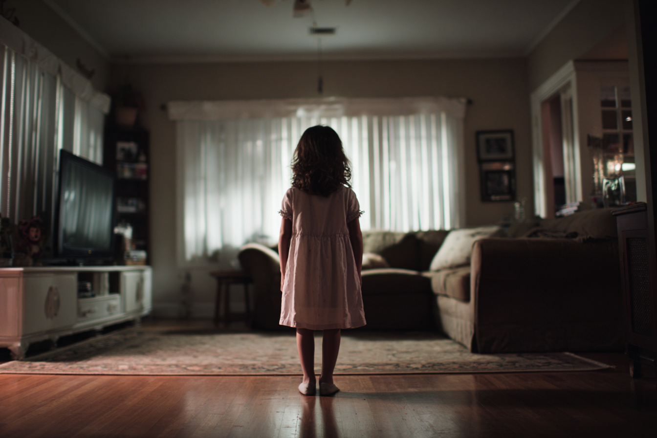 A little girl standing in a living room | Source: Midjourney
