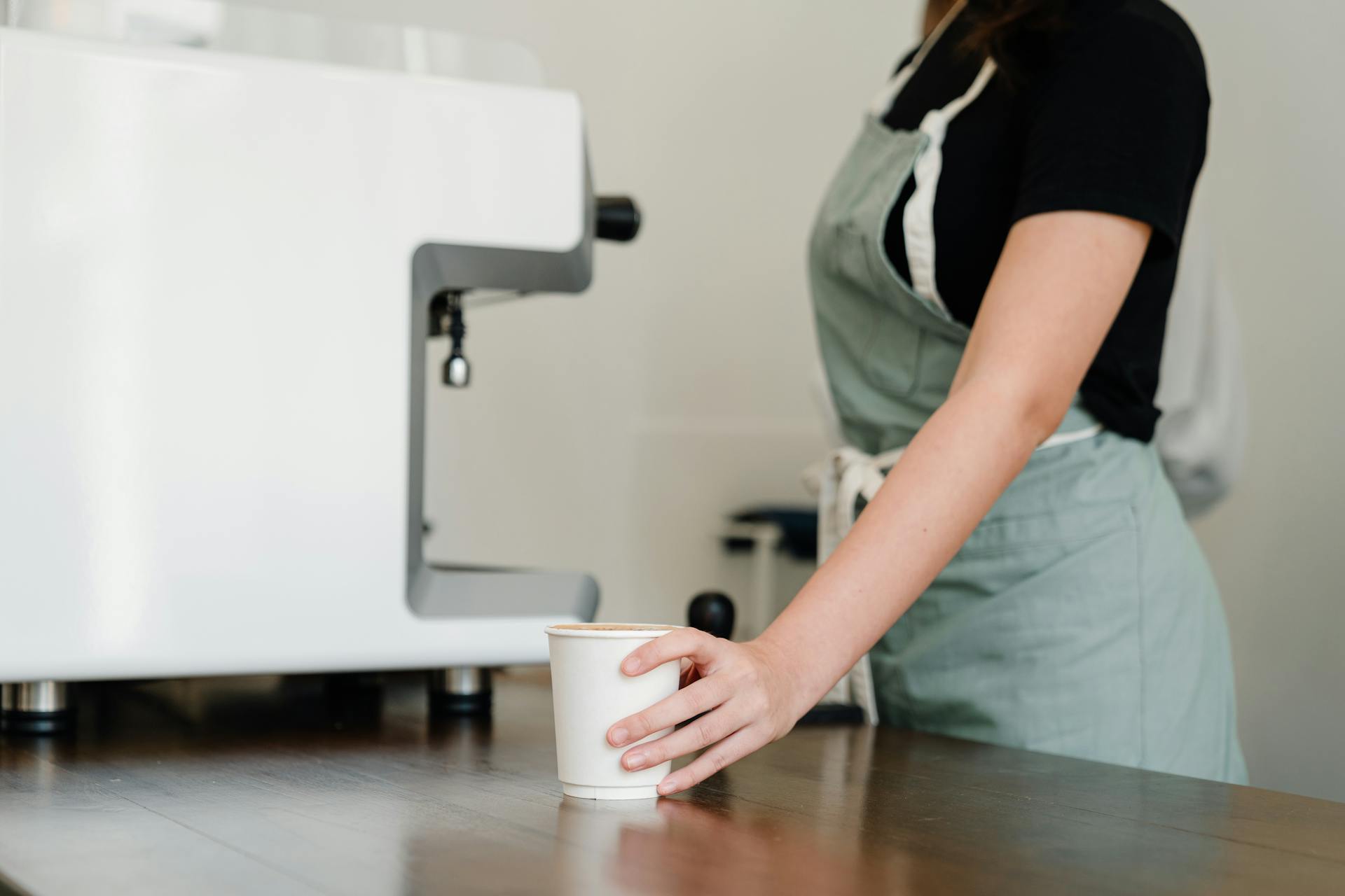 Cropped close-up shot of a waitress holding a coffee cup | Source: Pexels