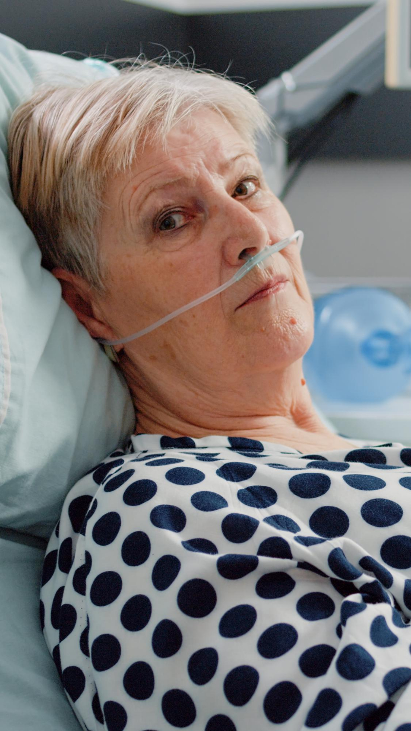 Close-up shot of a senior woman lying in a hospital ward | Source: Freepik