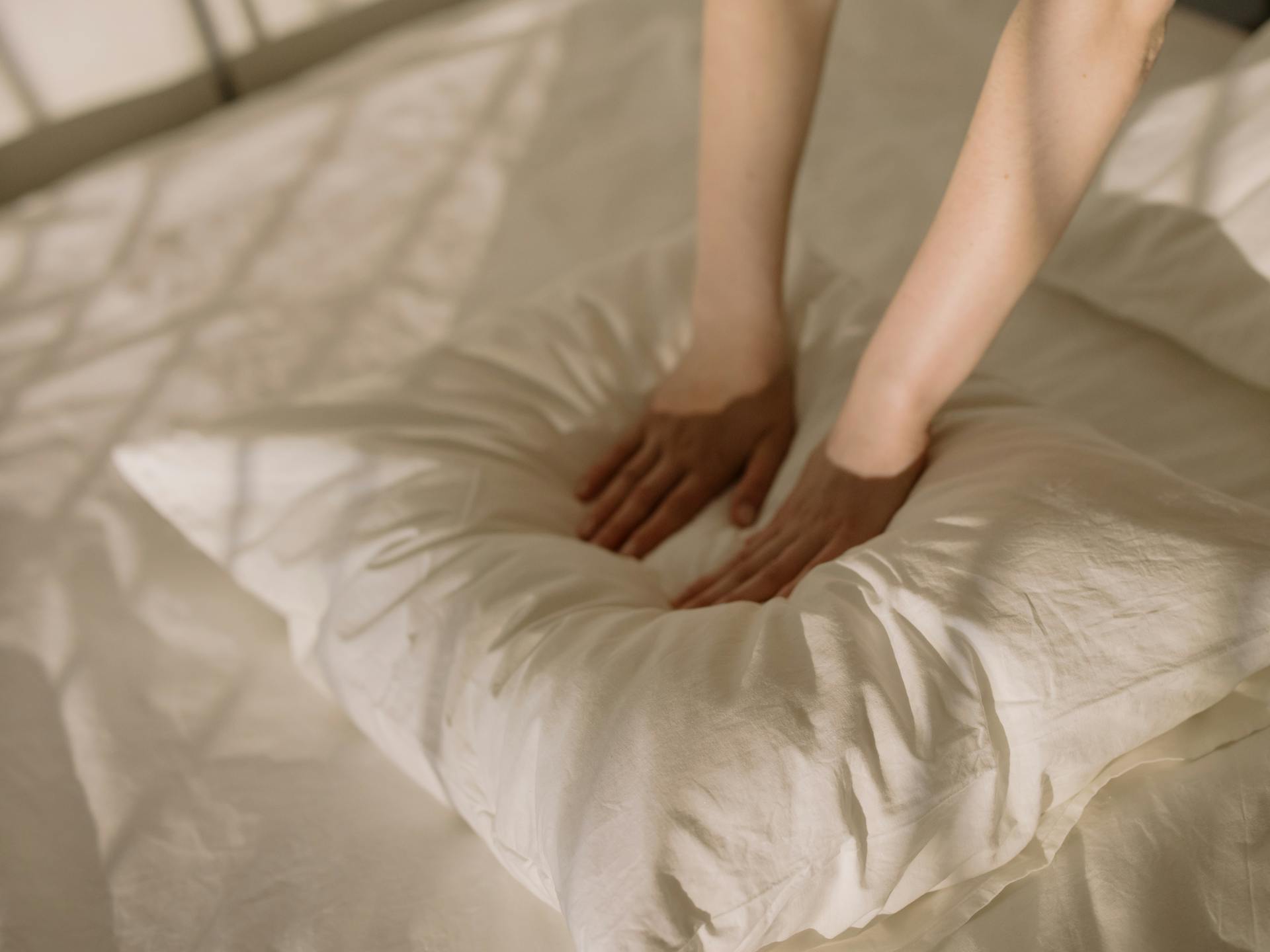 A woman grabbing a pillow | Source: Pexels