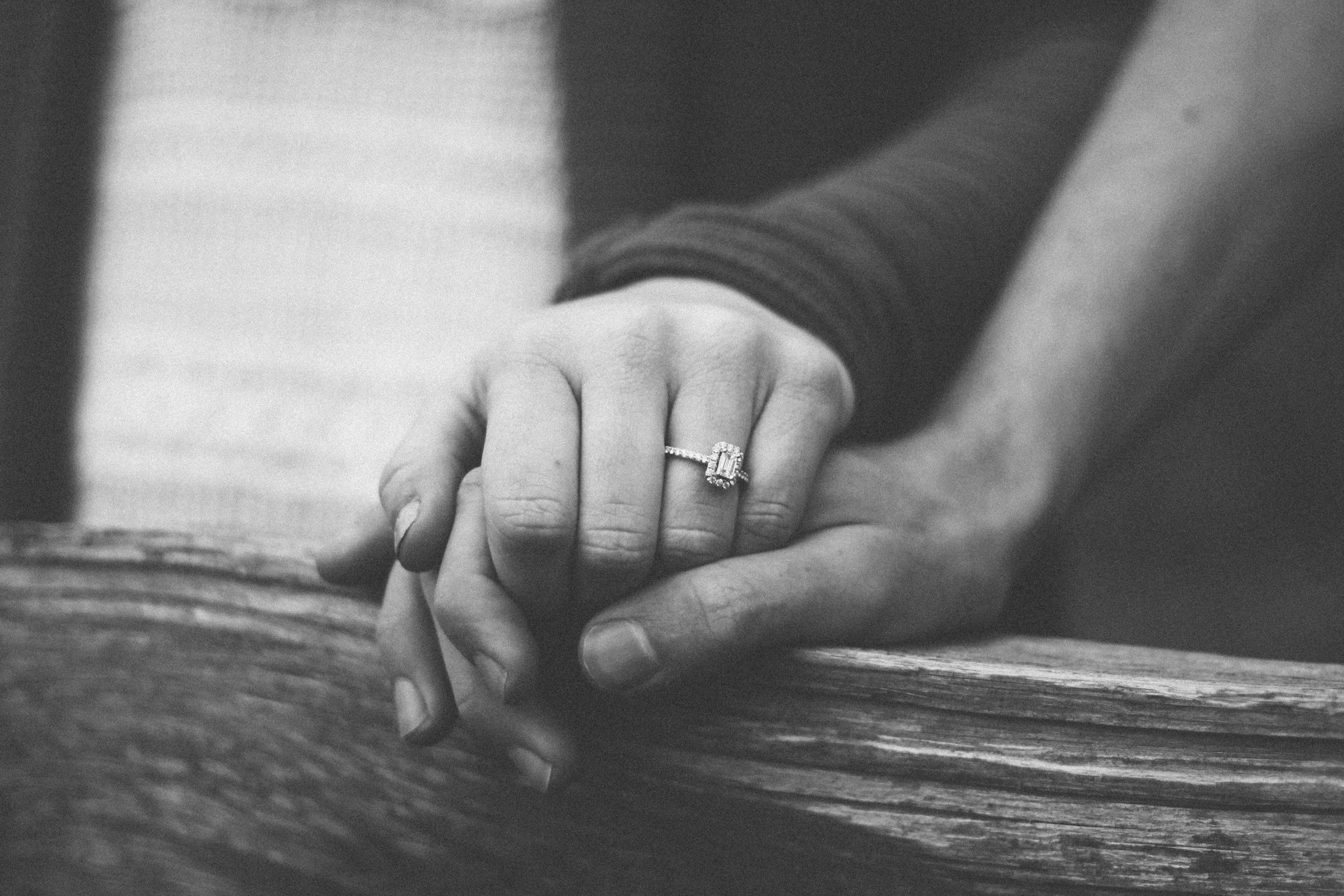 Grayscale close-up shot of a couple holding hands | Source: Unsplash