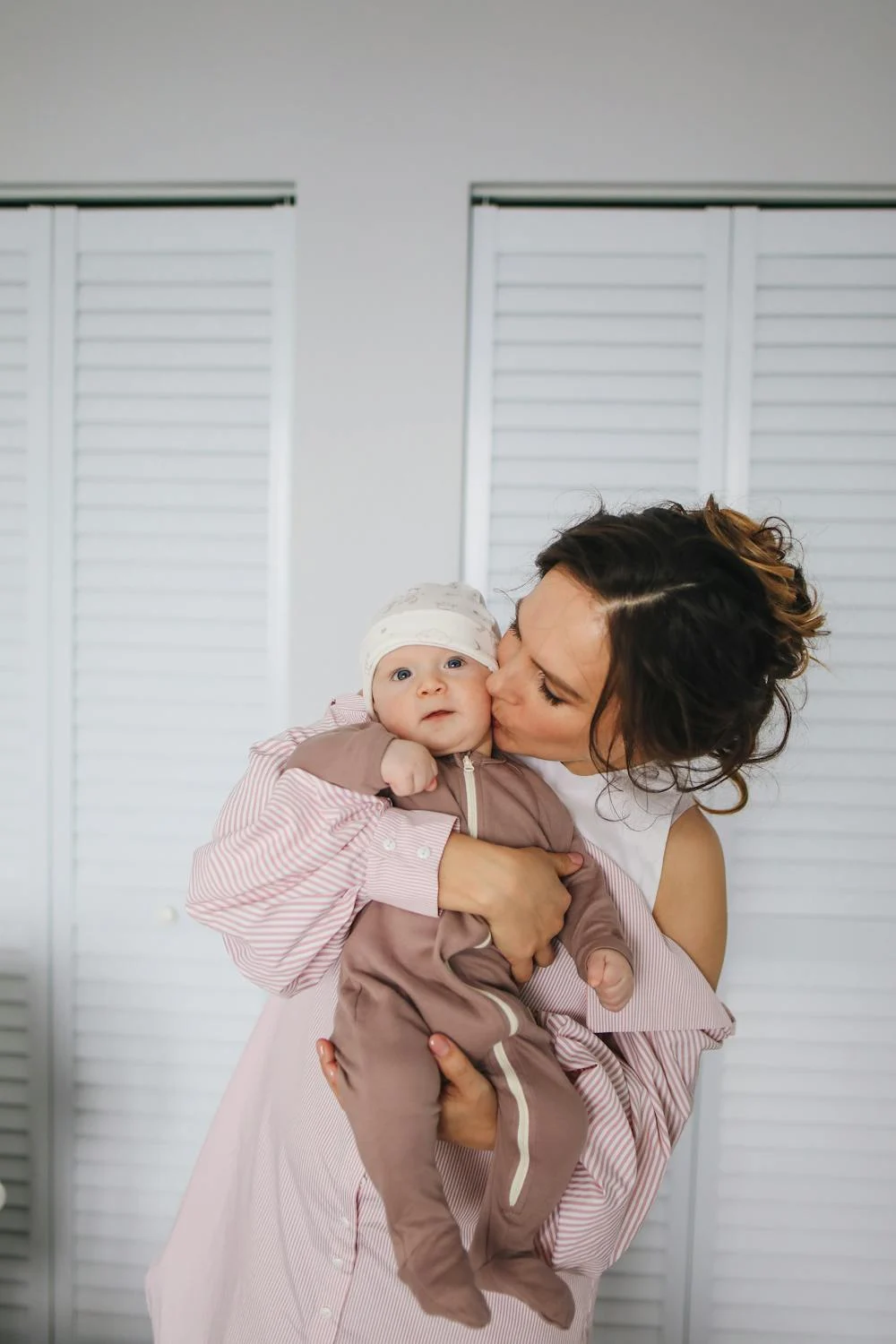 A woman kissing a baby | Source: Pexels