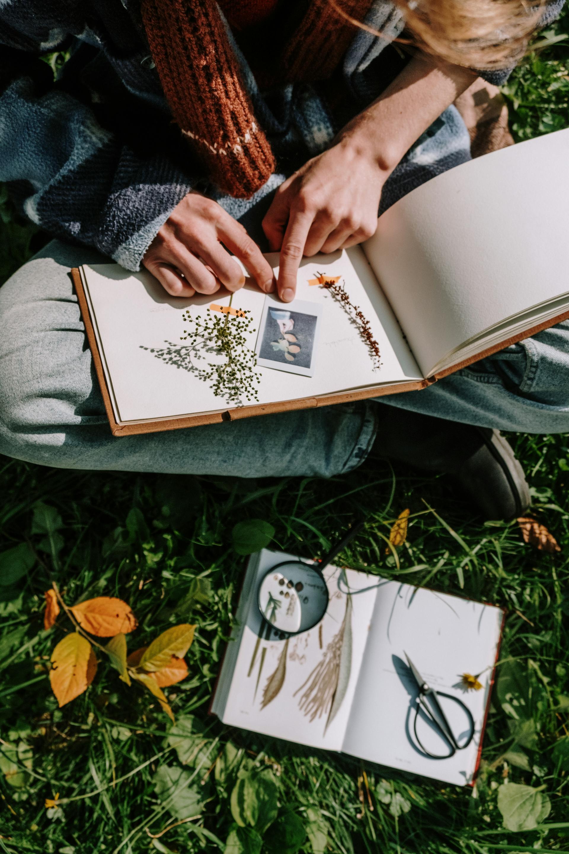 A woman sitting cross-legged and making a scrapbook | Source: Pexels