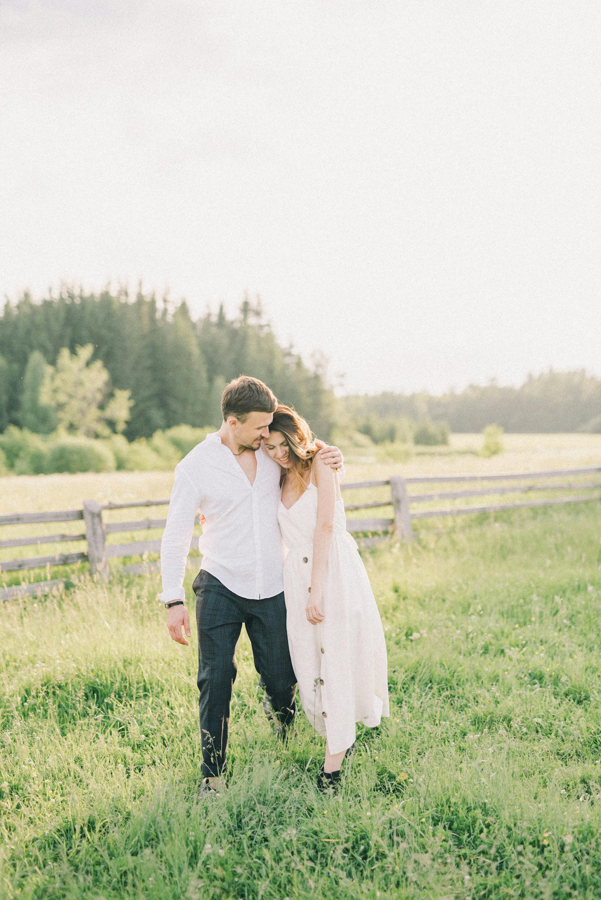 A happy couple walking in a field | Source: Pexels