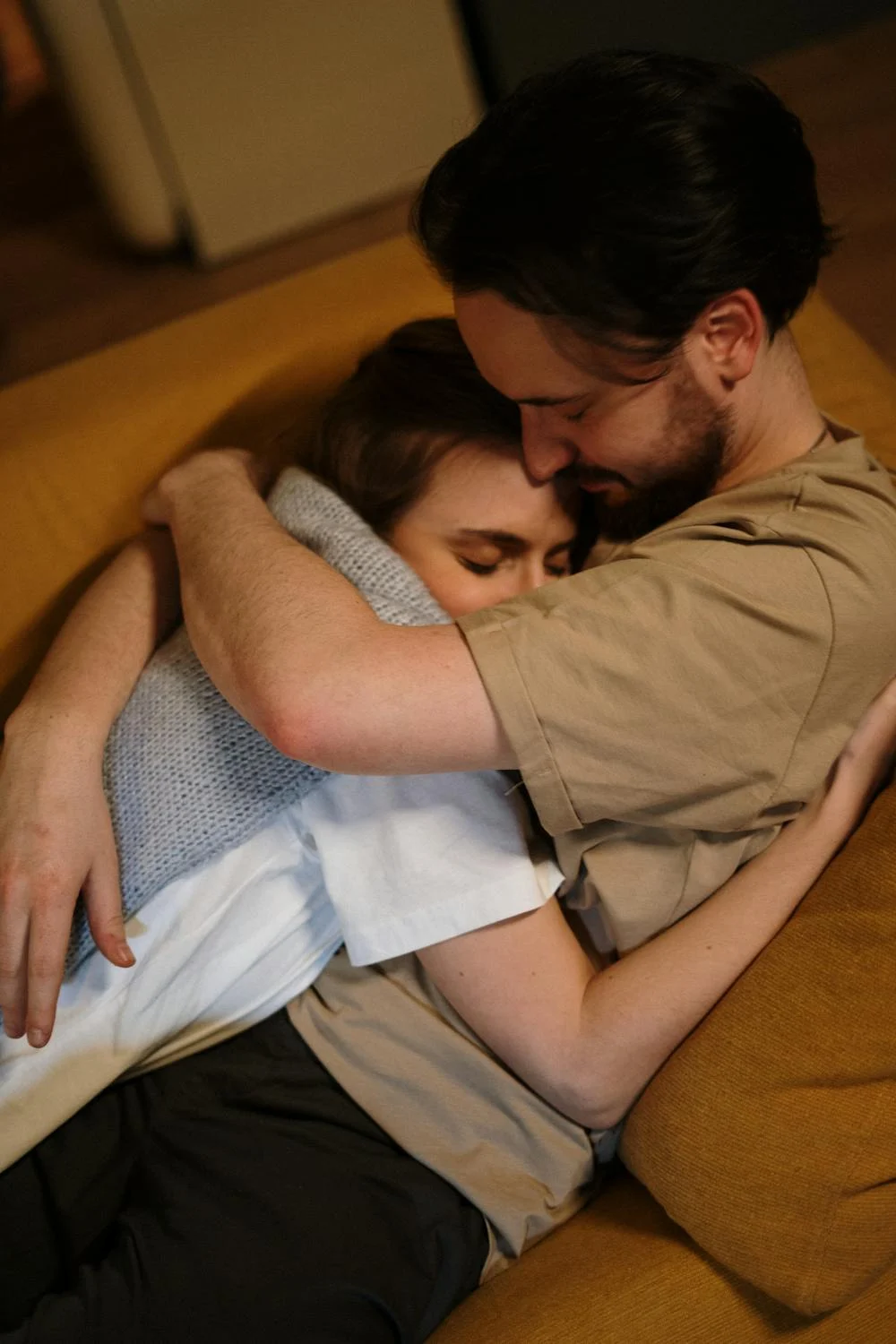 A couple hugging on a couch | Source: Pexels