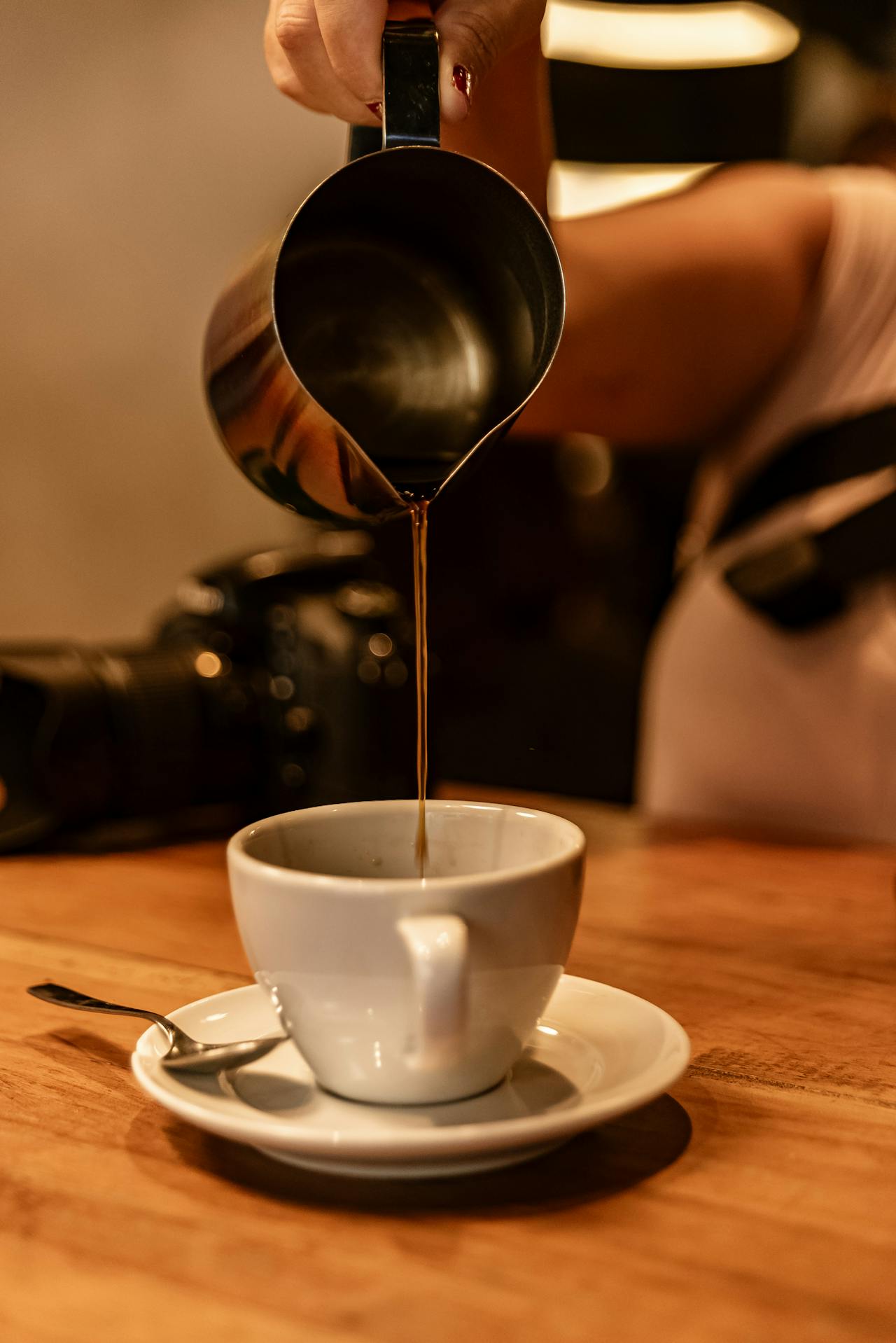A woman pouring coffee in a cup | Source: Pexels