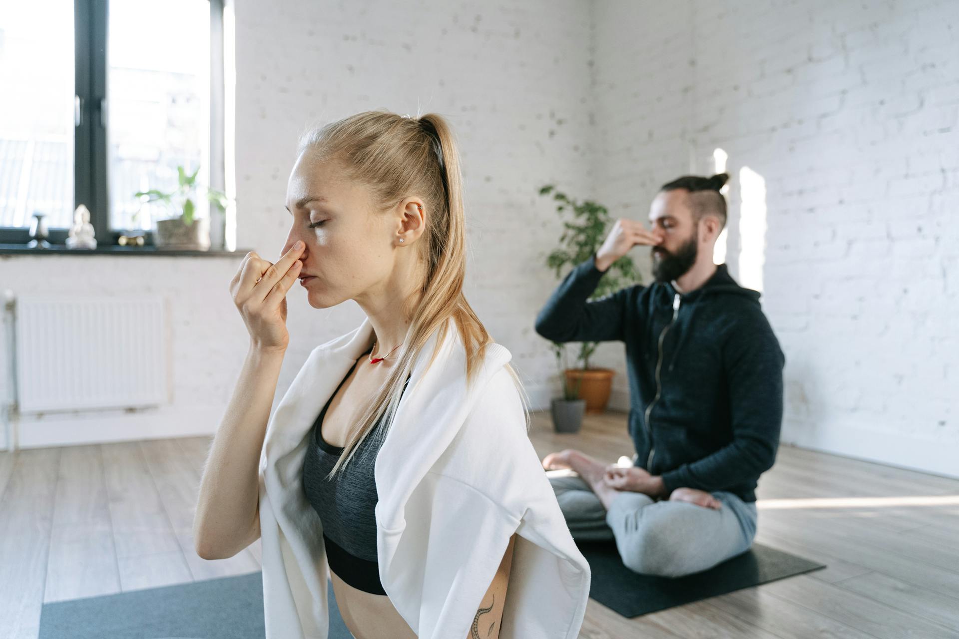 A couple practicing breathing exercises during a quiet yoga session | Source: Pexels