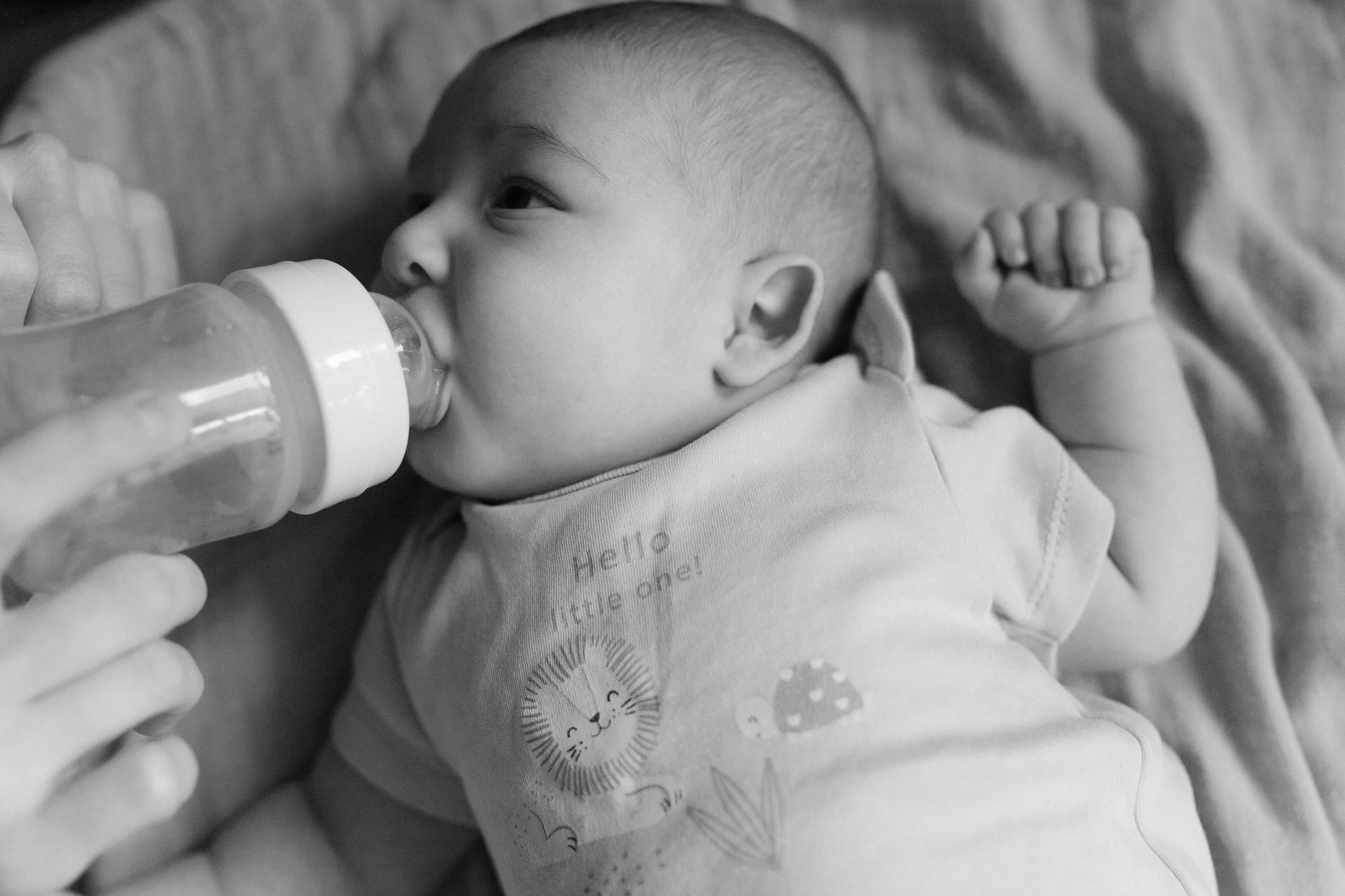 A parent holding a feeding bottle | Source: Pexels