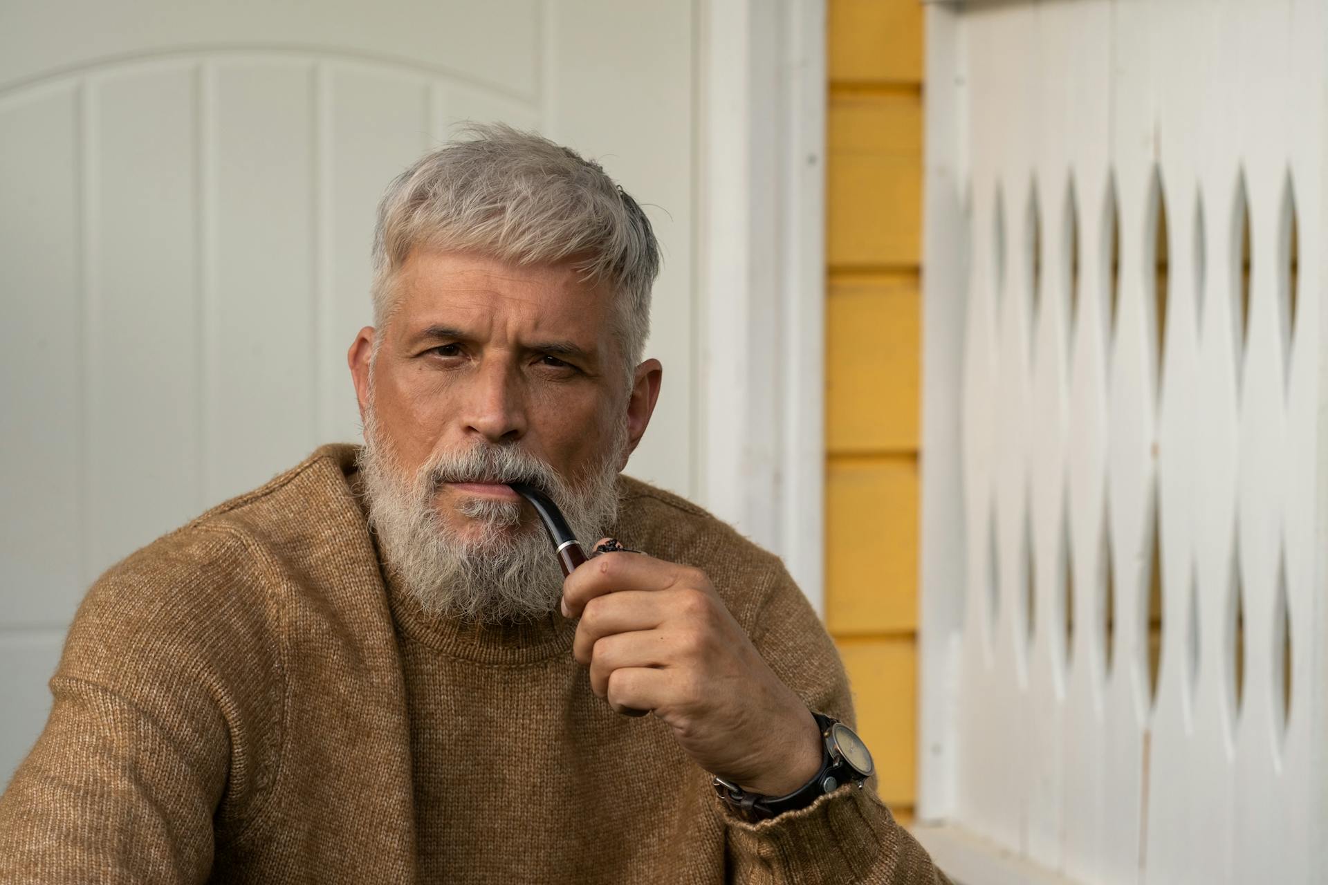A man sitting on the porch with a pipe | Source: Pexels