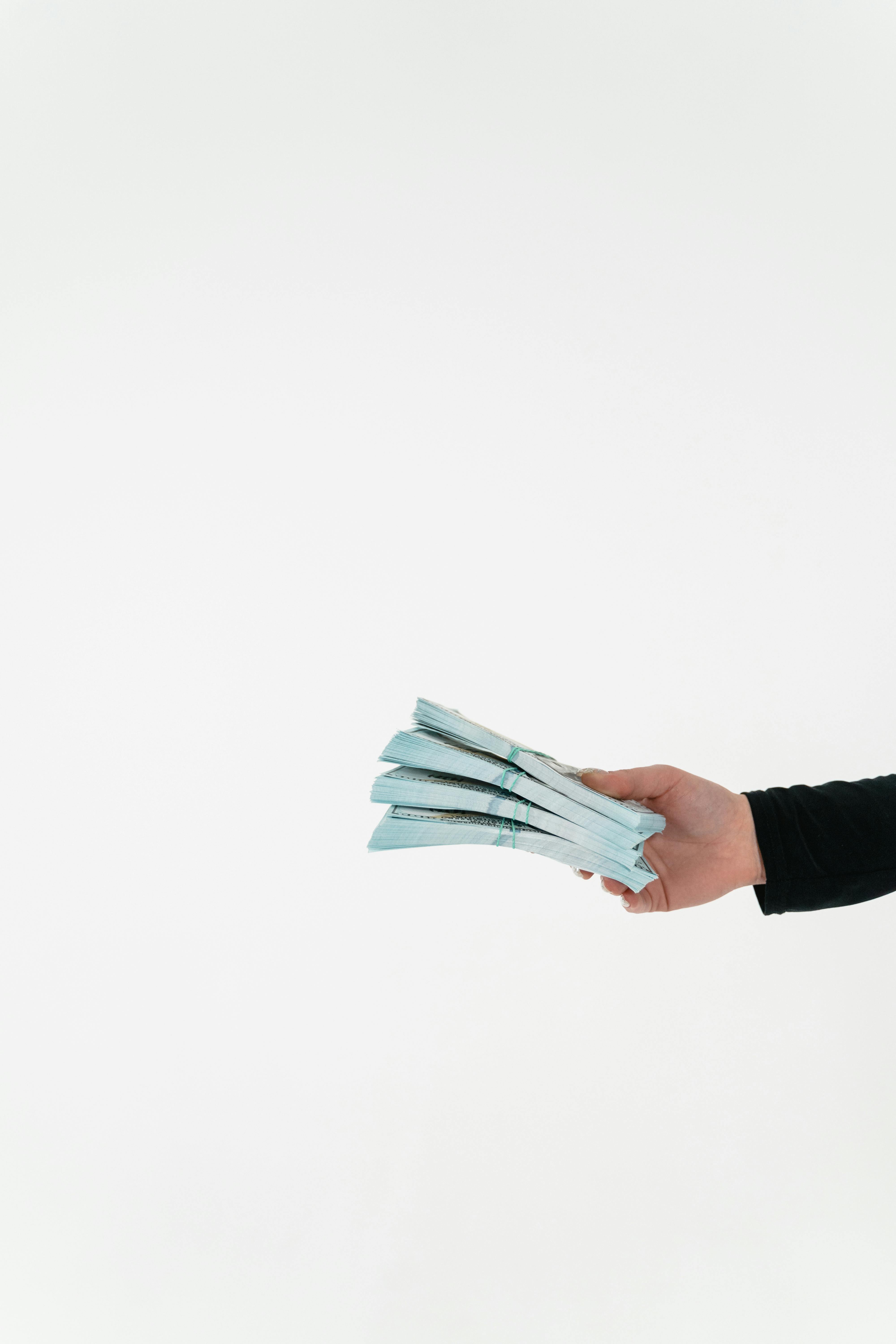 A person holding bundles of cash | Source: Pexels
