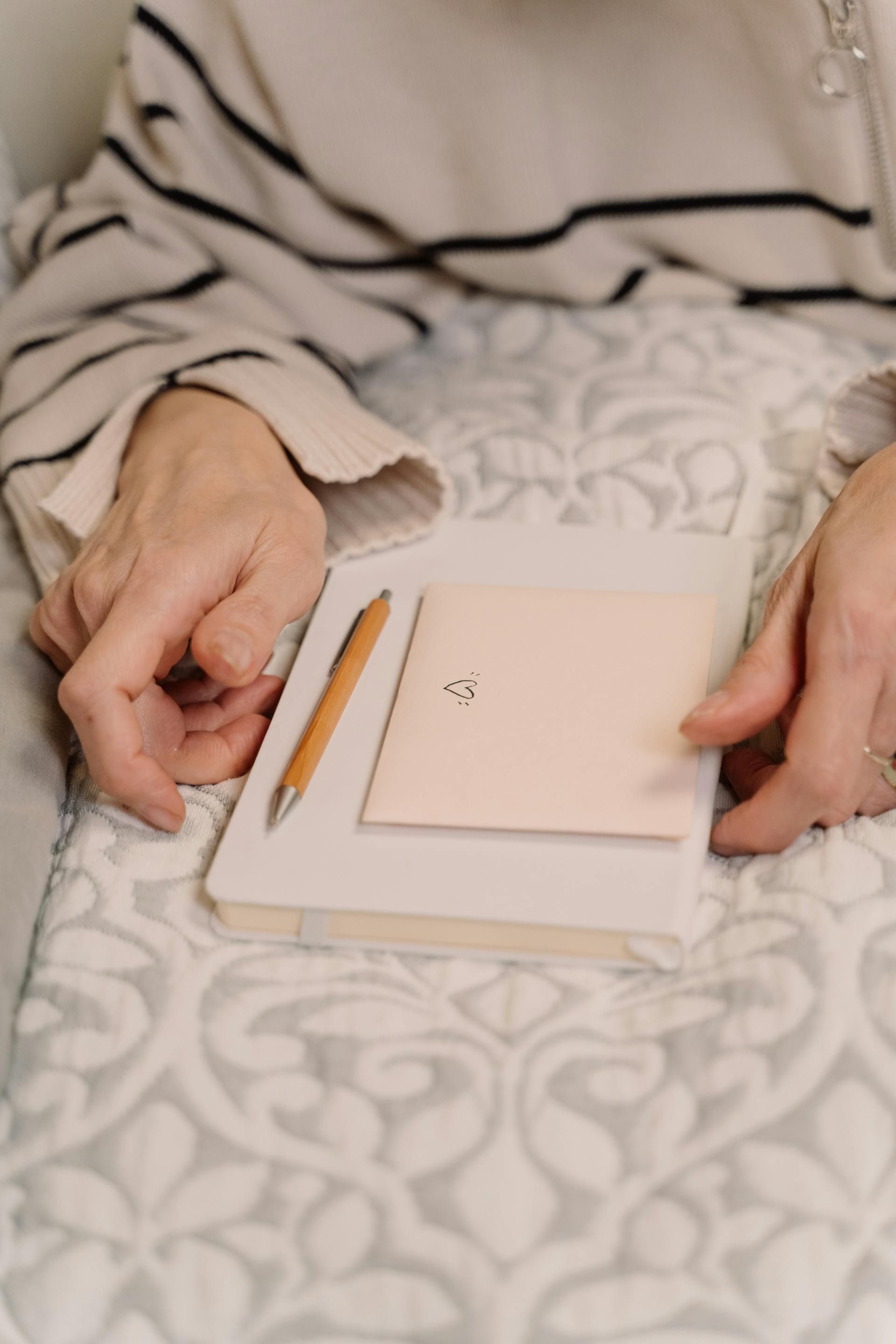 Close-up shot of a woman holding a diary and an envelope | Source: Pexels