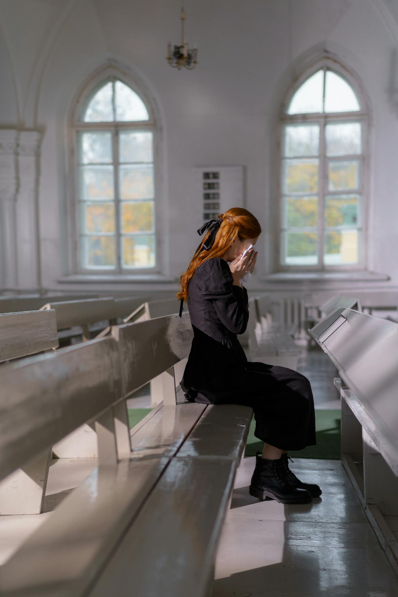 A lonely and emotional woman sitting in the church and crying | Source: Pexels