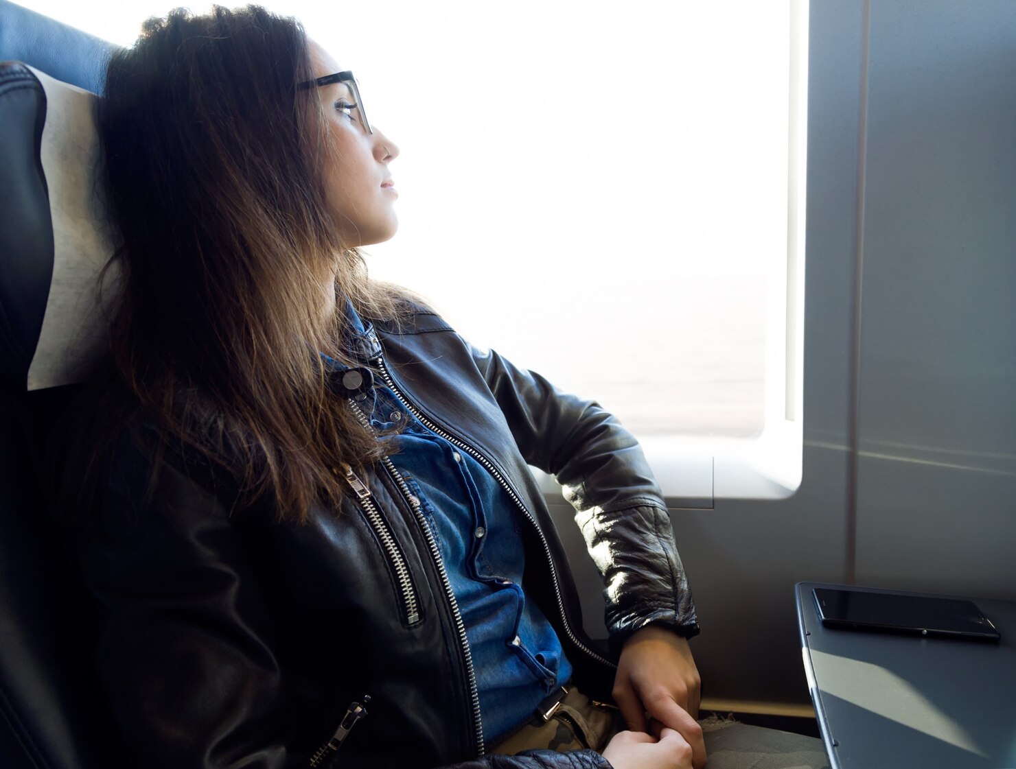 A thoughtful woman on a plane | Source: Freepik