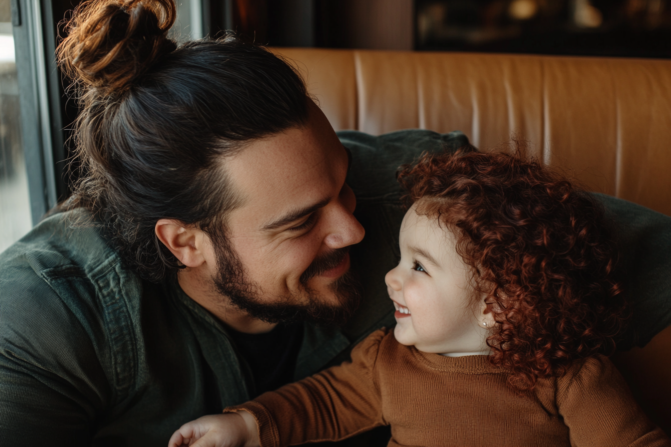 A man and a 3-year-old toddler smiling at each other | Source: Midjourney