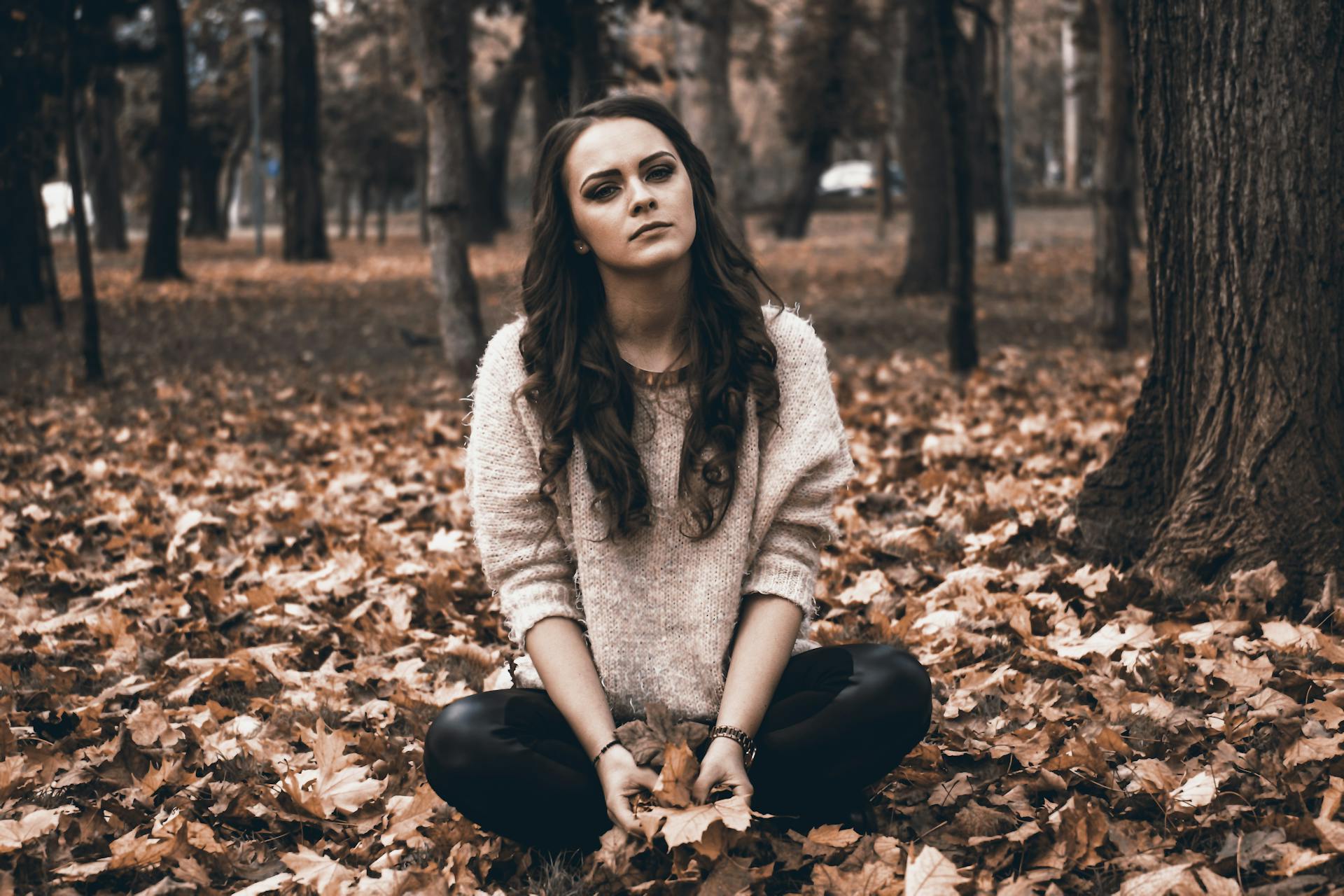 A young woman sitting alone in a forest | Source: Pexels