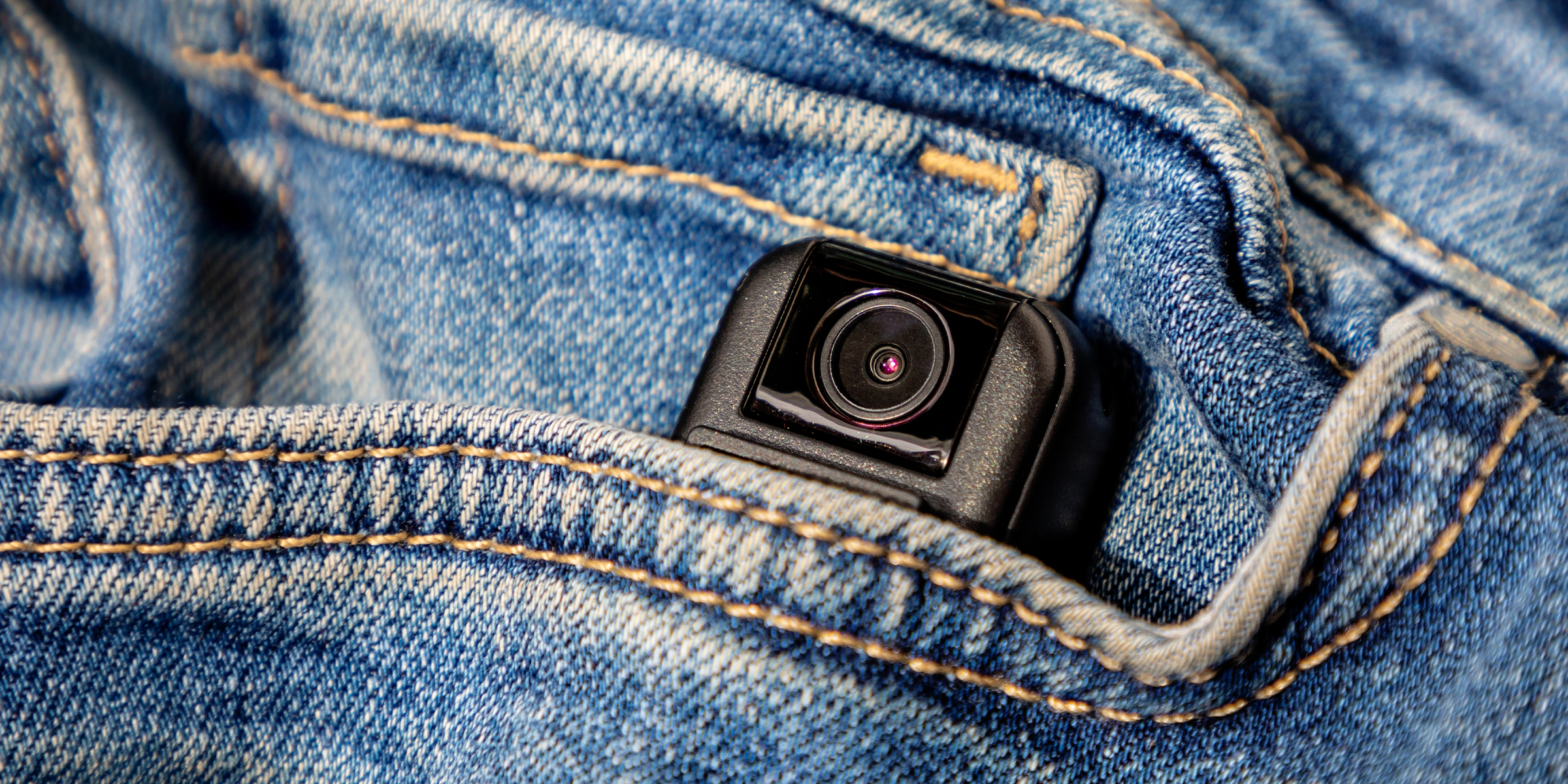 A small hidden camera peeking out from the front pocket of a pair of blue jeans | Source: Shutterstock