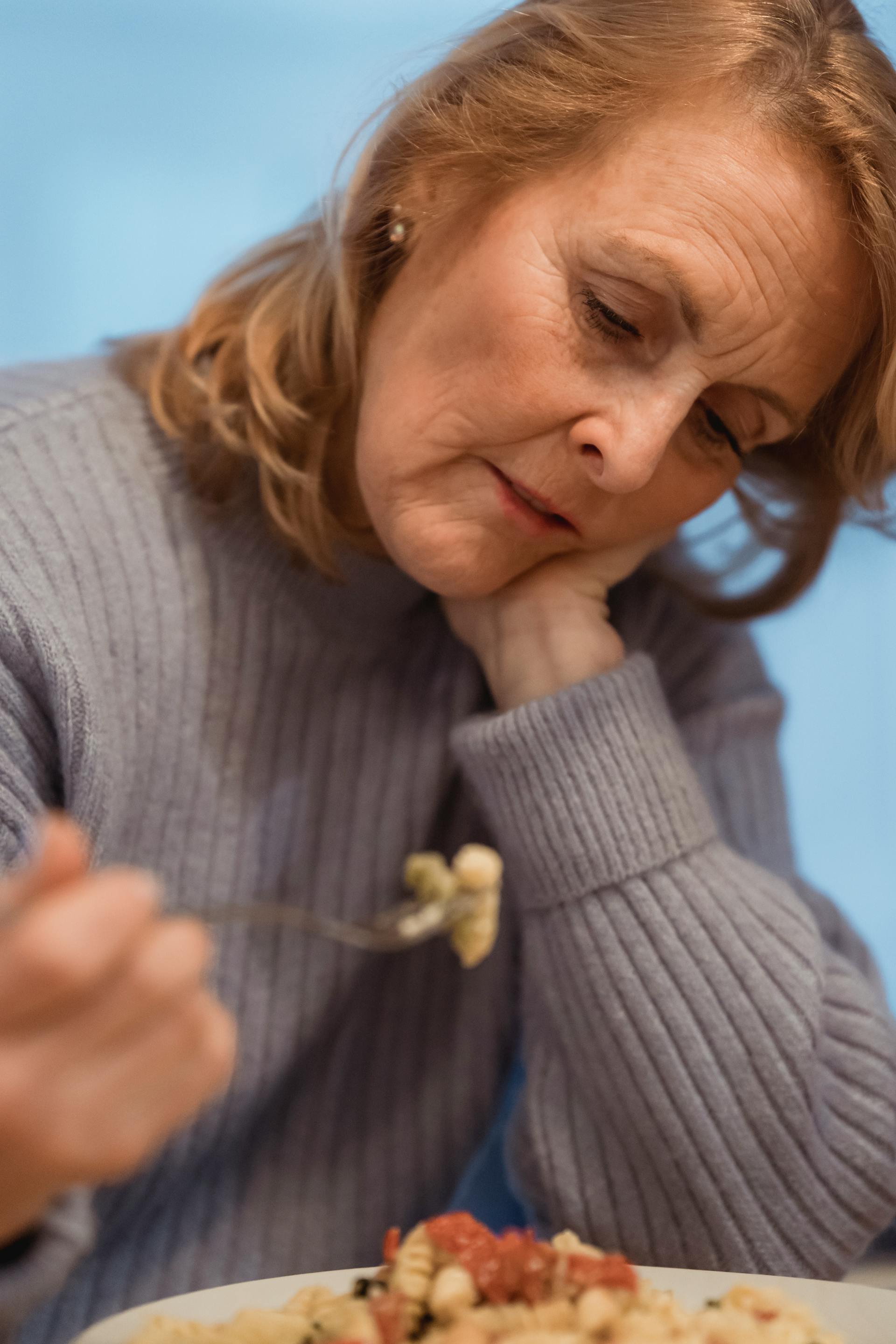 A woman staring down at her plate of food | Source: Pexels