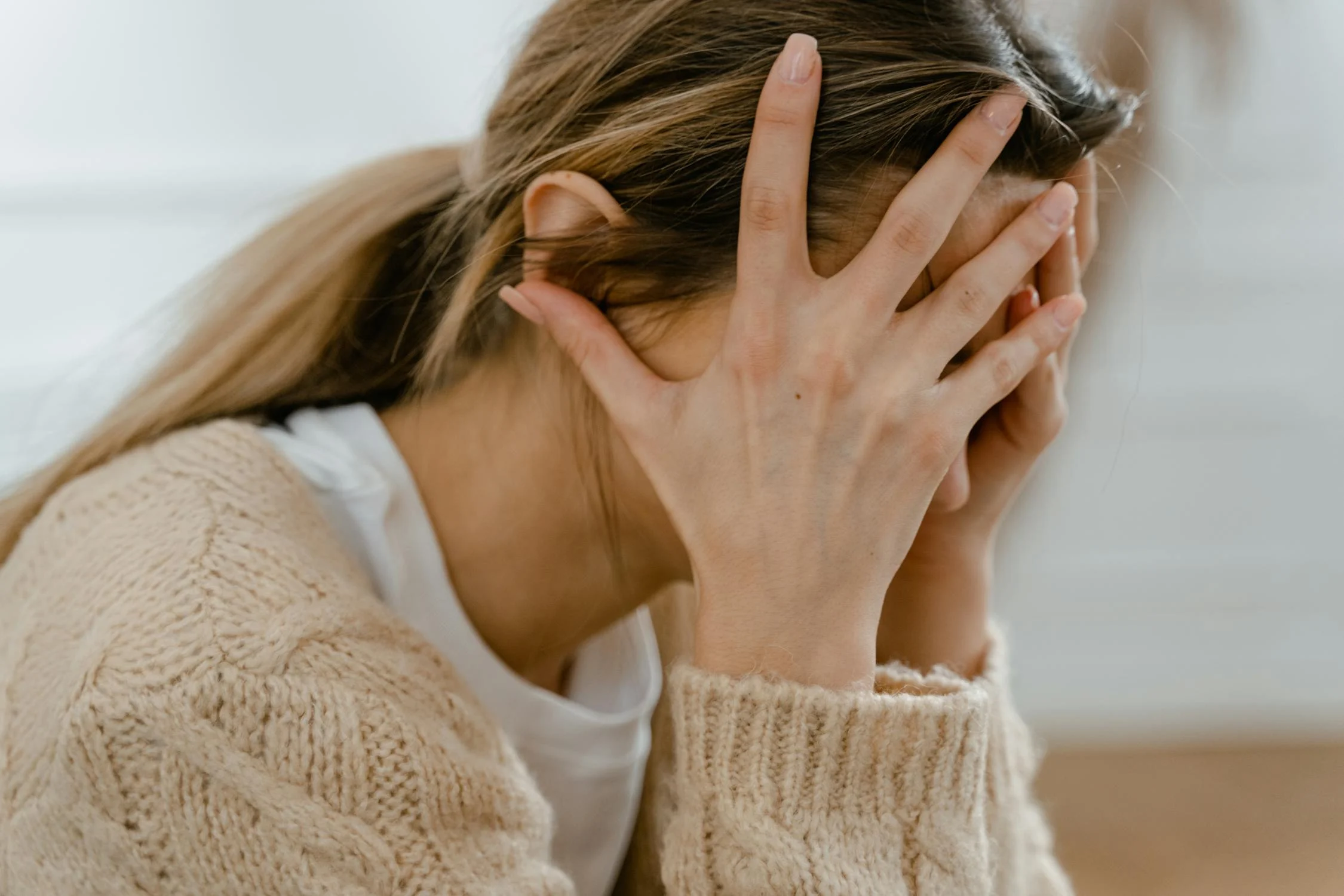 A woman holding her head thinking | Source: Pexels