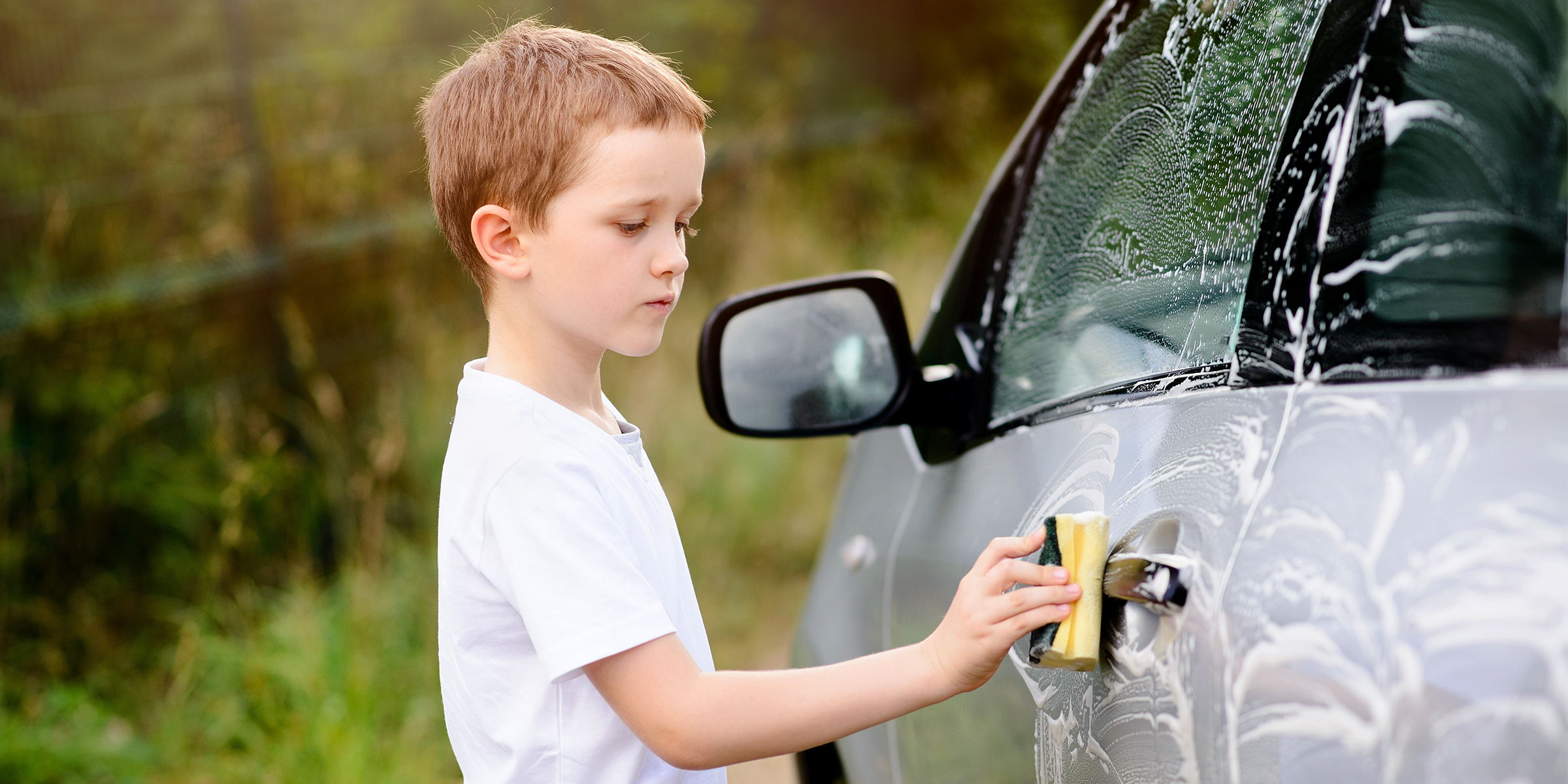 A boy cleaning a car | Source: Shutterstock