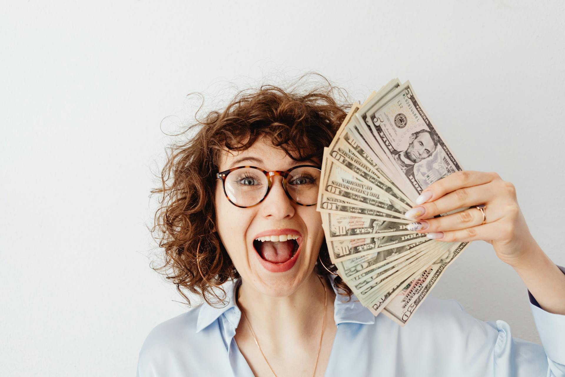 A woman holding up money | Source: Pexels
