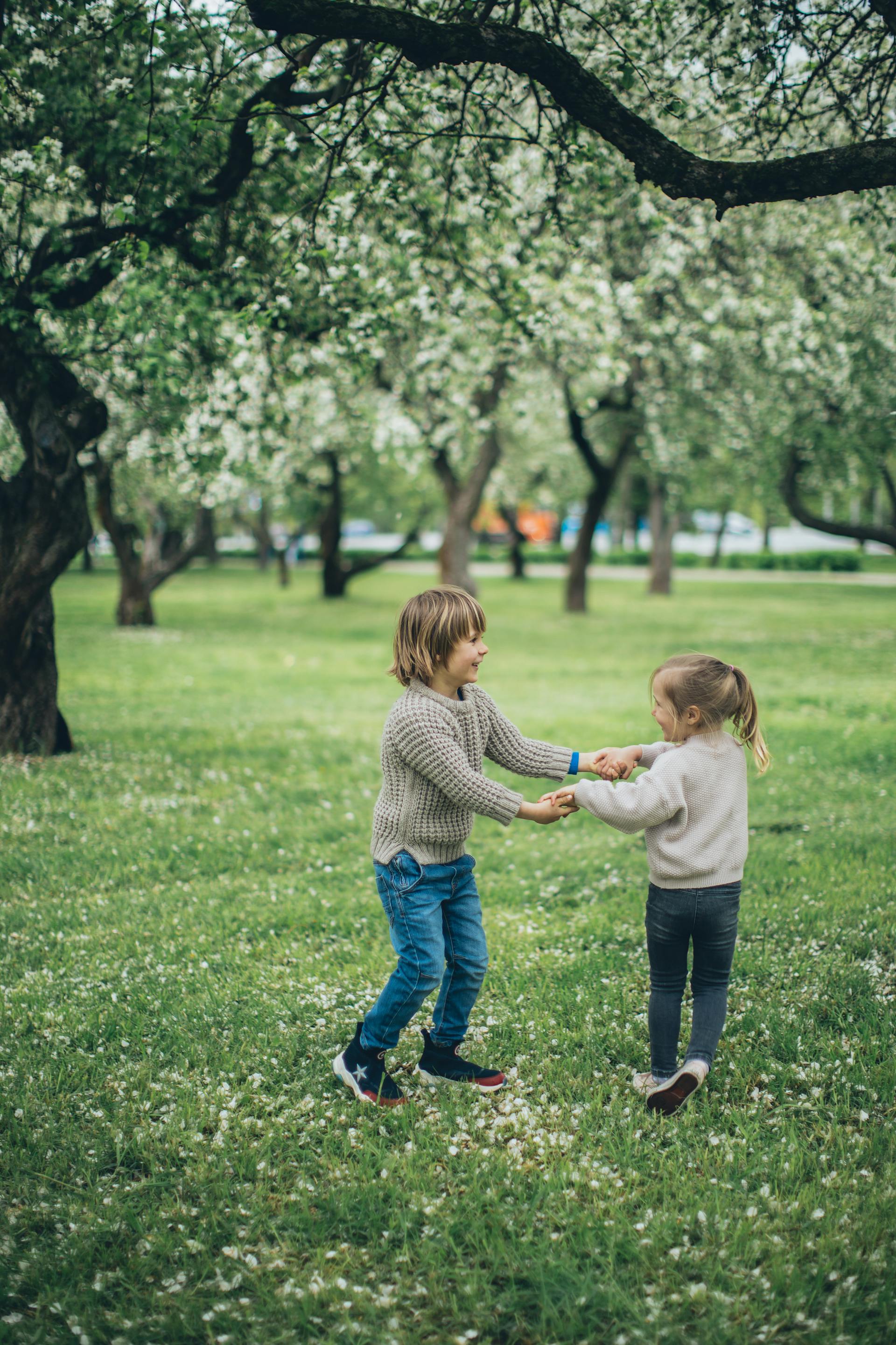 Two kids playing on a grassy field | Source: Pexels