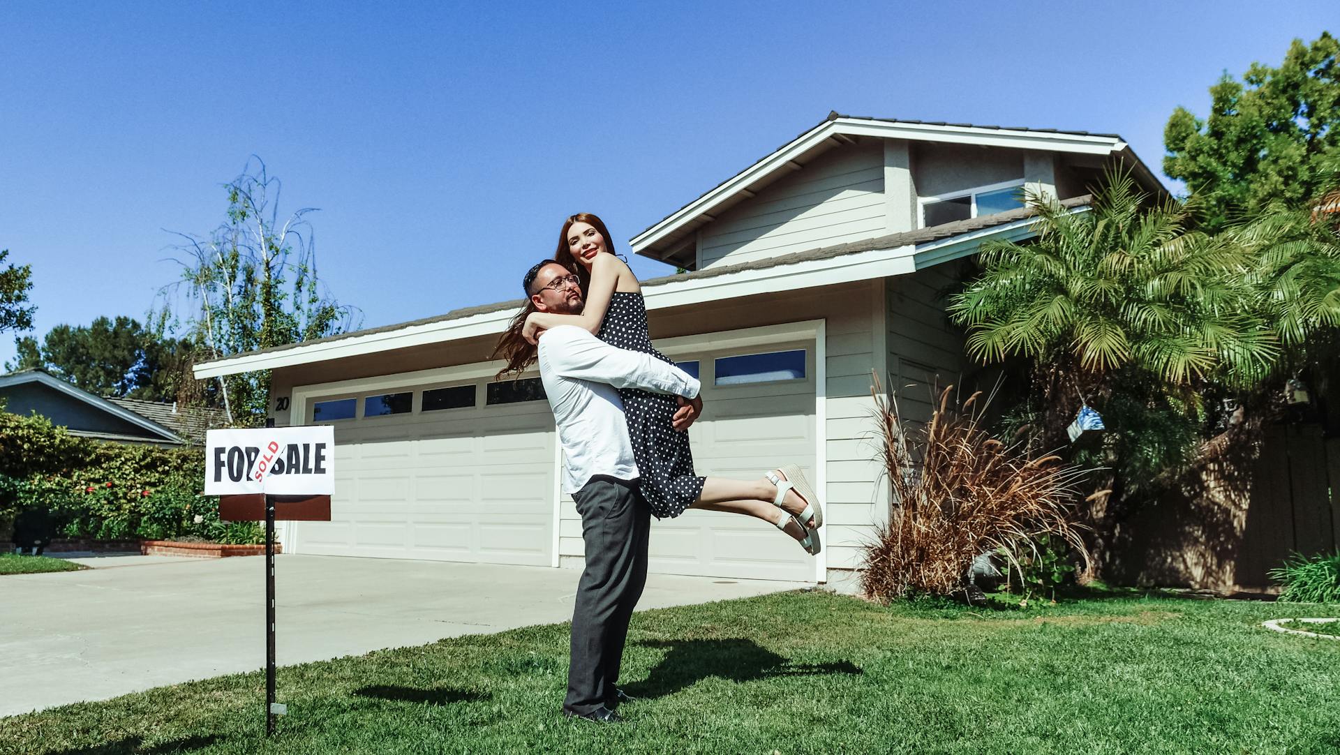A happy couple celebrating outside the house they just bought | Source: Pexels