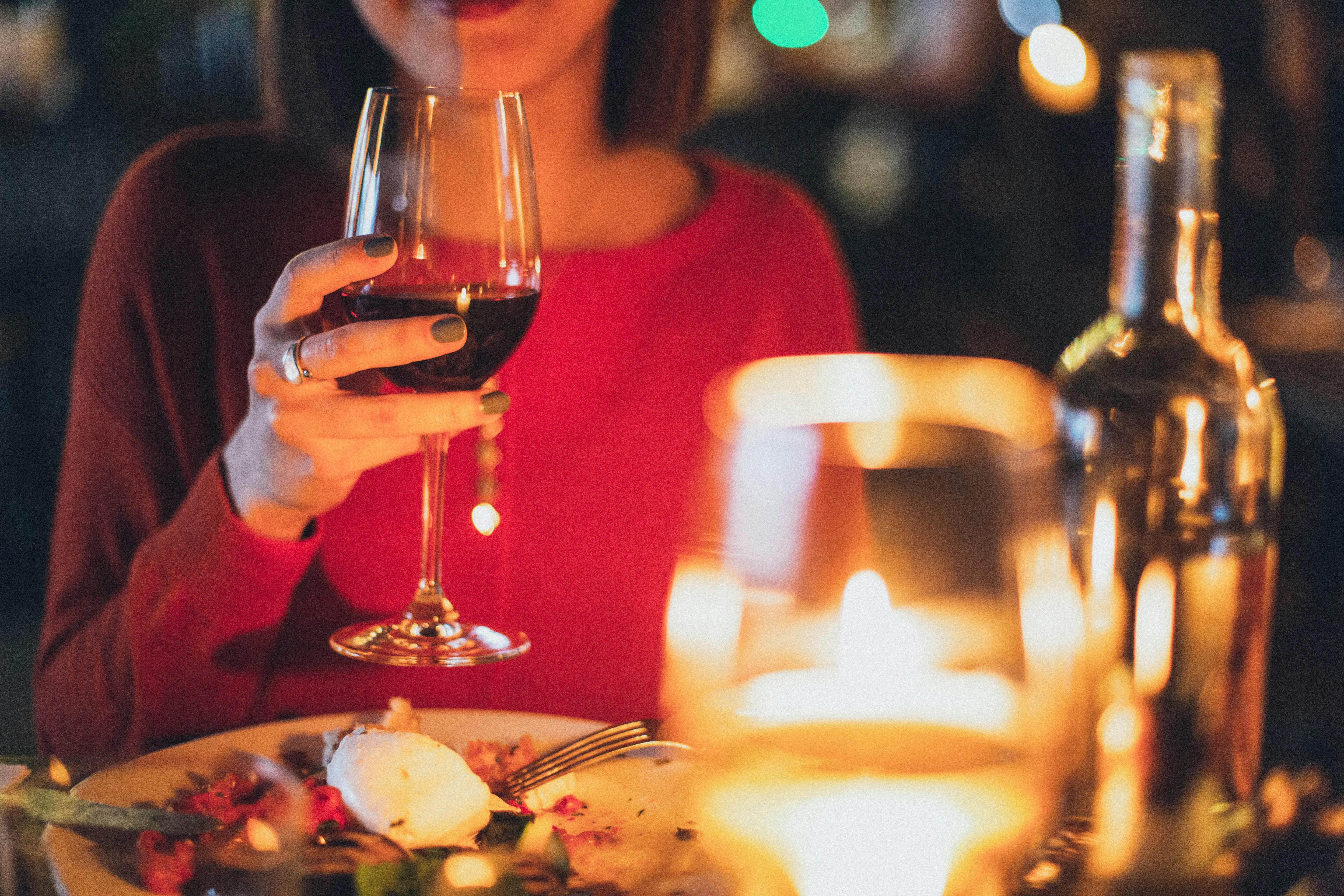 Woman holding a glass of wine | Source: Midjourney