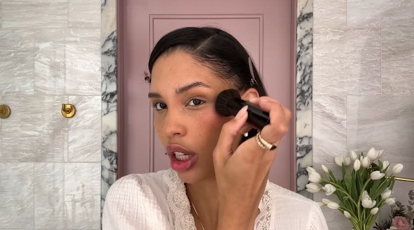Nara Smith doing her makeup routine from a video dated December 12, 2024. | Source: YouTube/Vogue