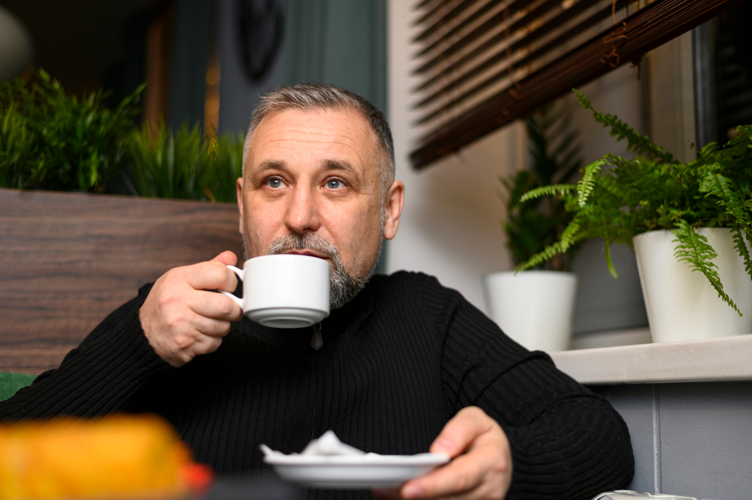 An anxious man holding a ceramic cup | Source: Freepik