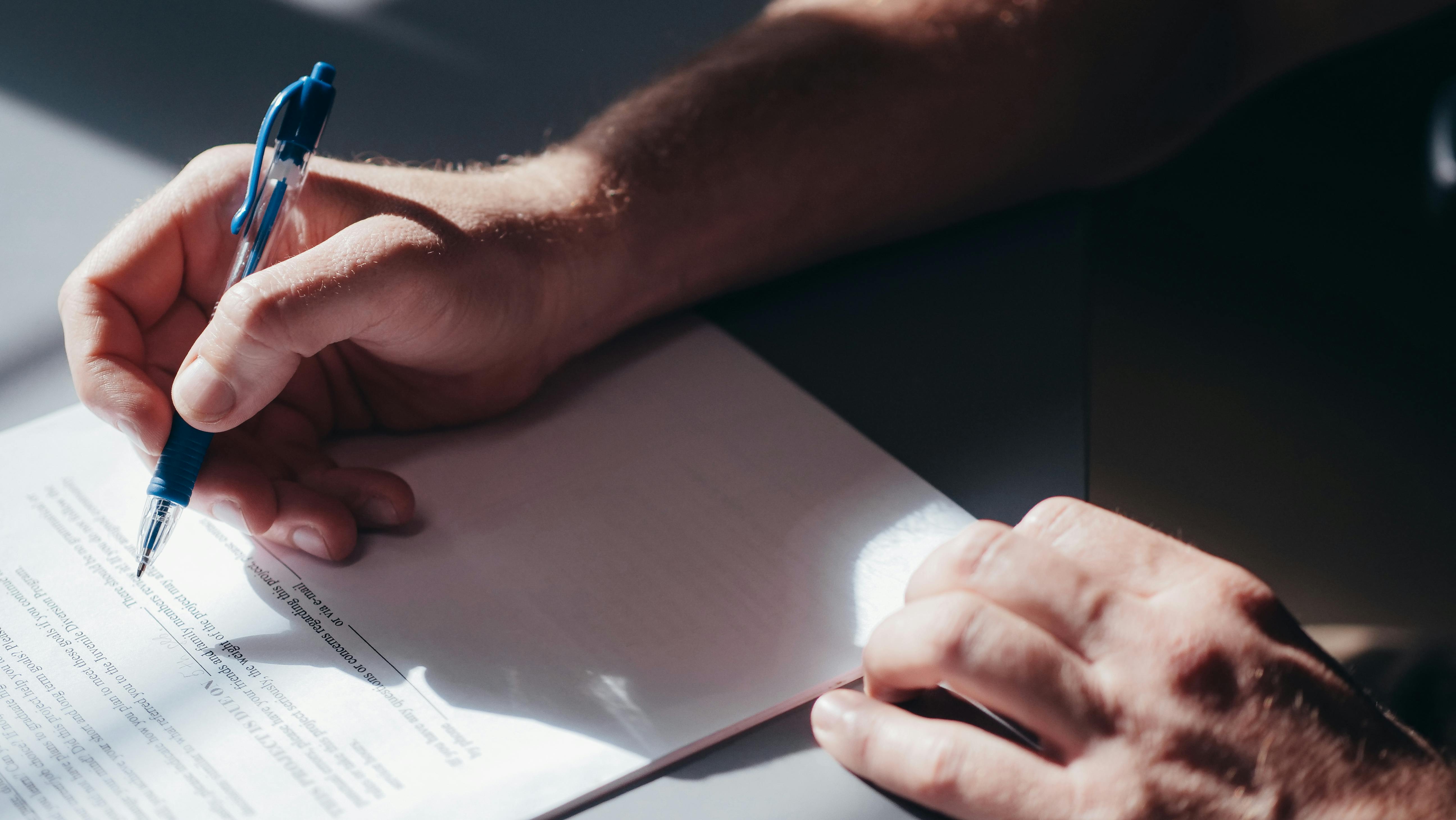 A person signing a document | Source: Pexels