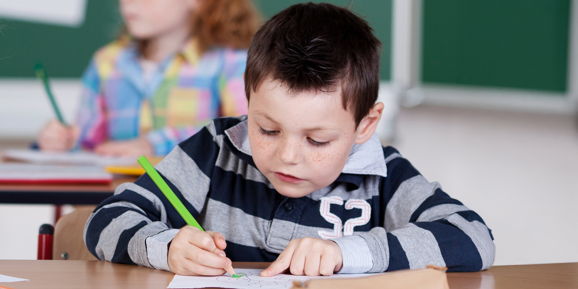 A boy drawing a picture in class | Source: Shutterstock
