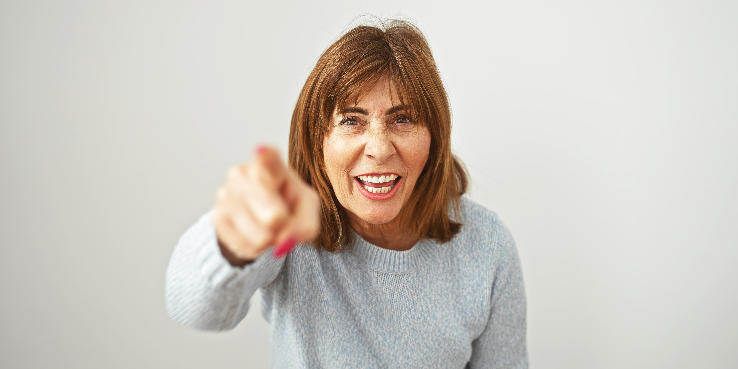 A woman angrily pointing forward | Source: Shutterstock