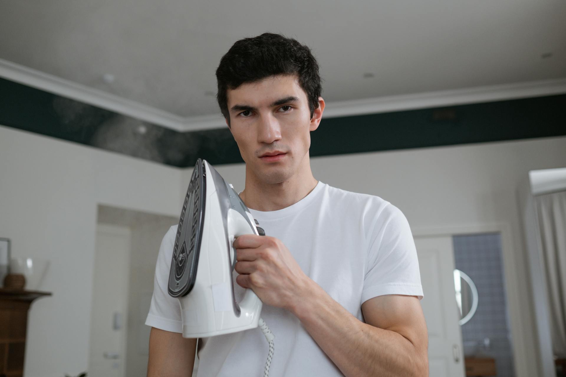 A man holding a hot clothes iron | Source: Pexels