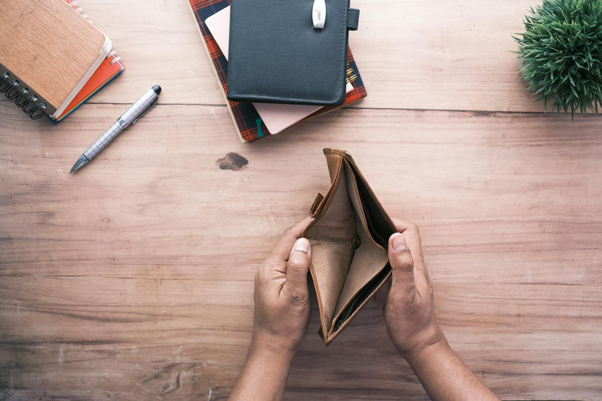 A man looking at his empty wallet | Source: Pexels