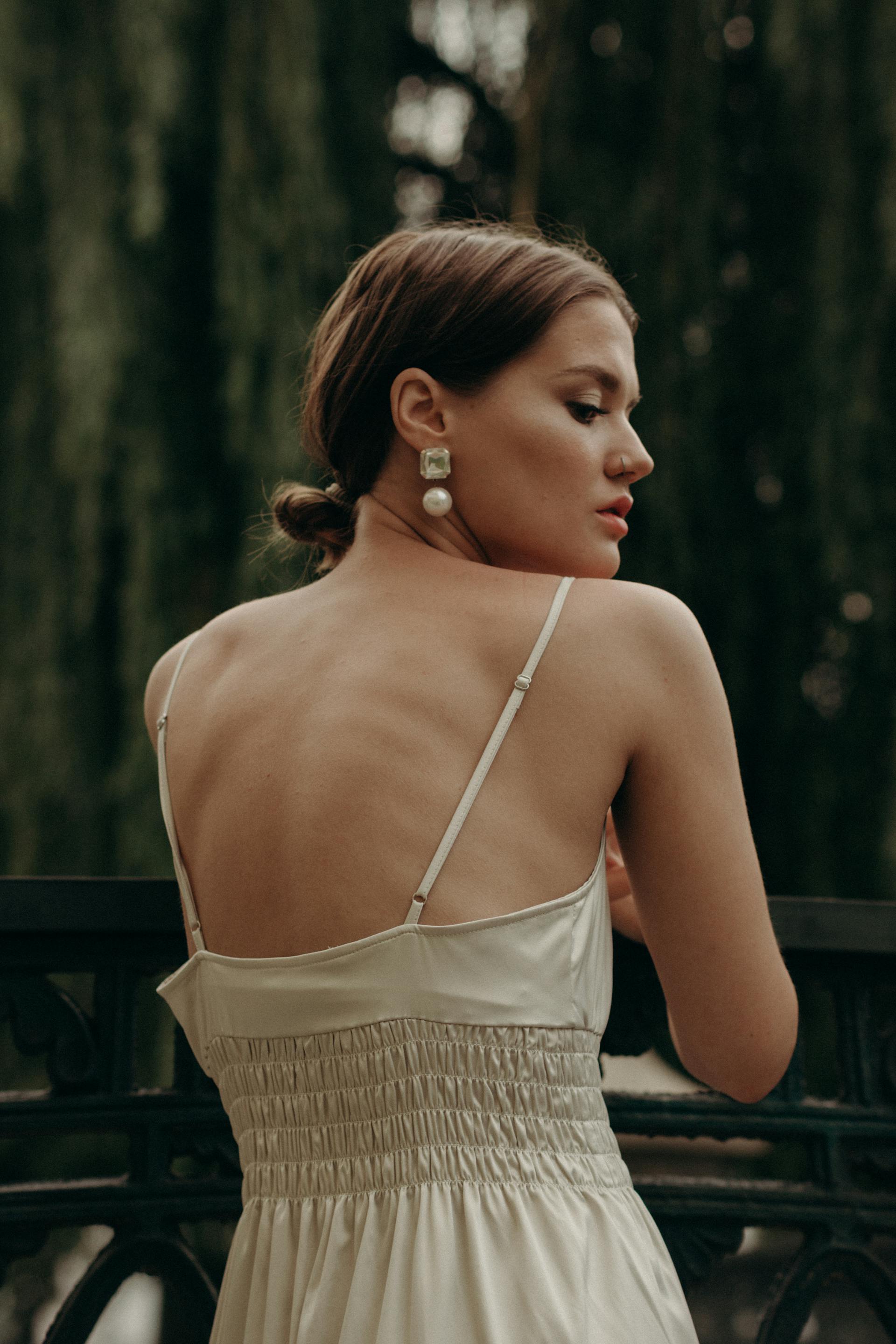 Uma mulher de vestido branco usando brincos combinando | Fonte: Pexels