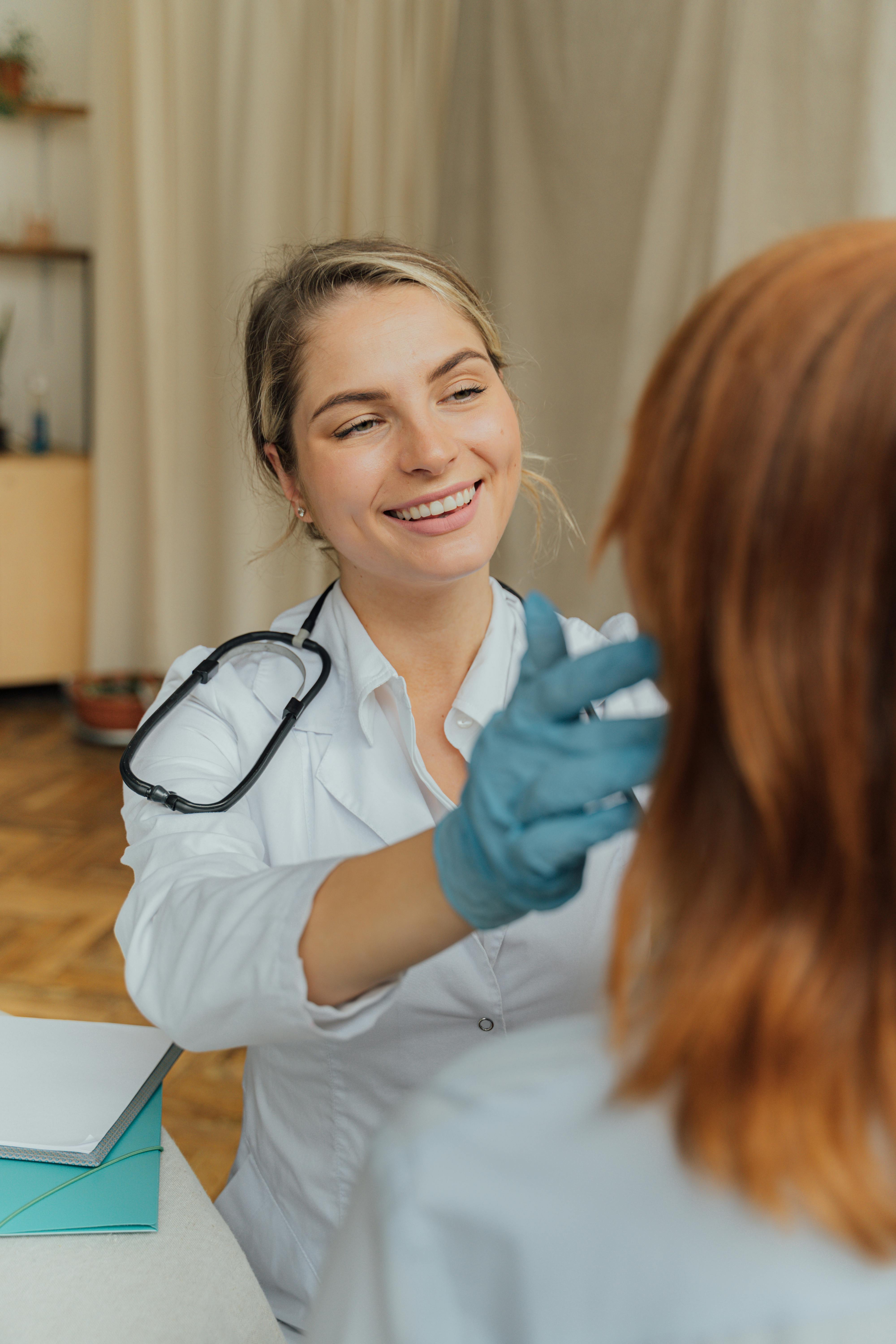 A happy nurse assisting a patient | Source: Pexels