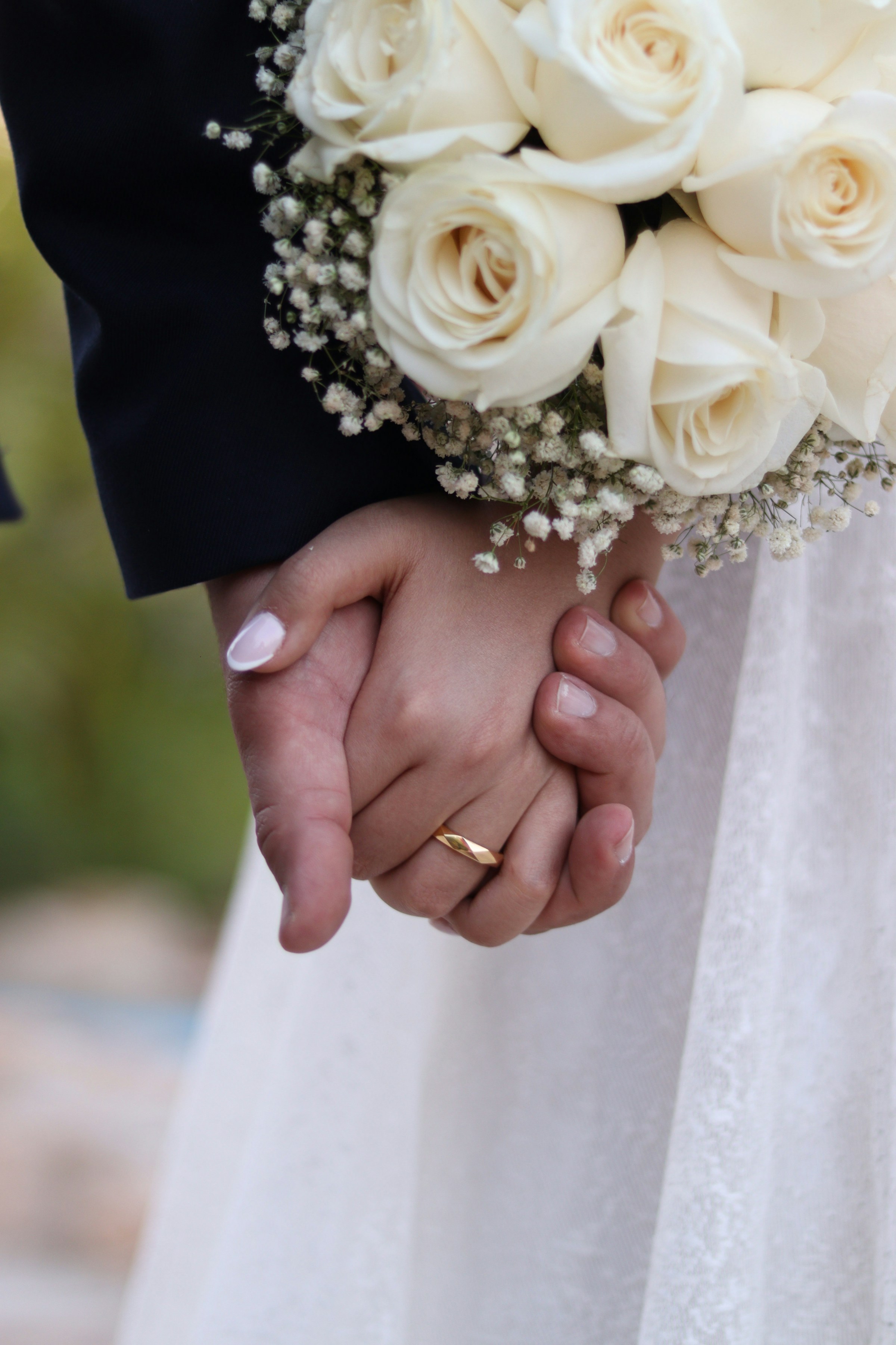 Close-up of a bride and groom holding hands | Source: Unsplash