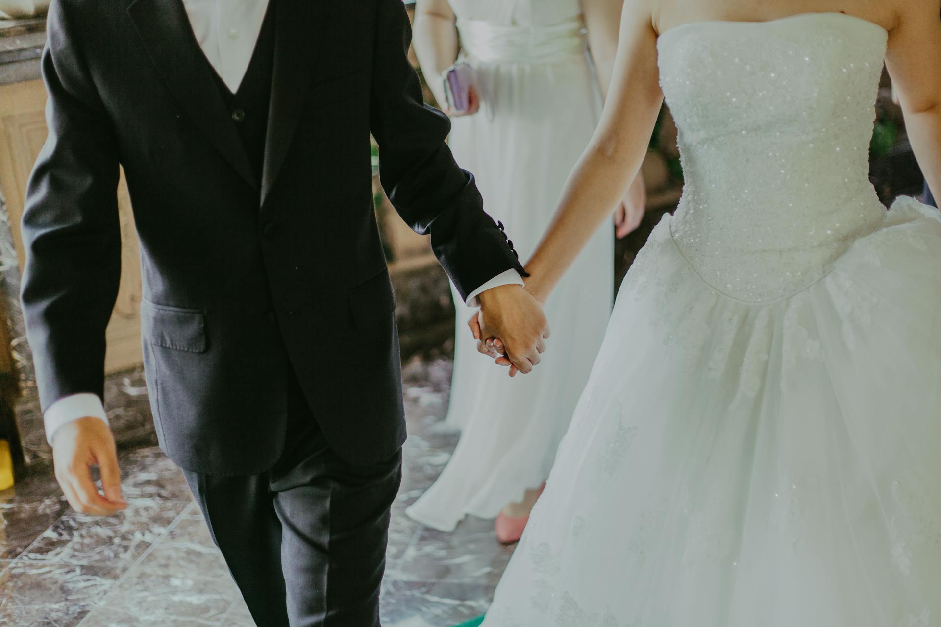 A couple holding hands on their big day | Source: Pexels