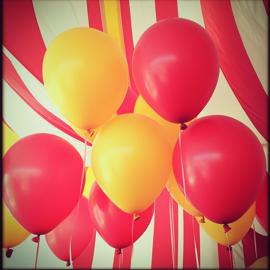 Red and yellow balloons at a circus themed baby shower | Source: Midjourney