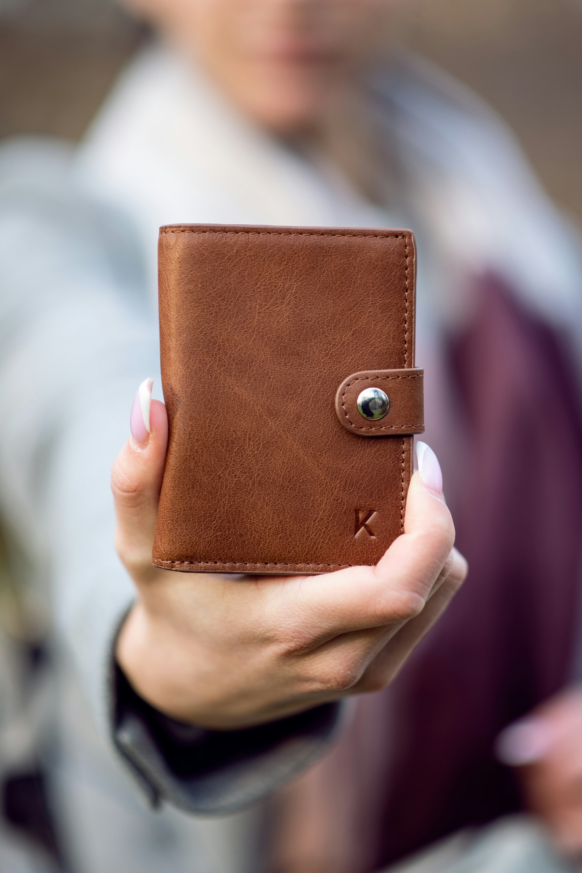 A woman holding a brown leather wallet | Source: Unsplash
