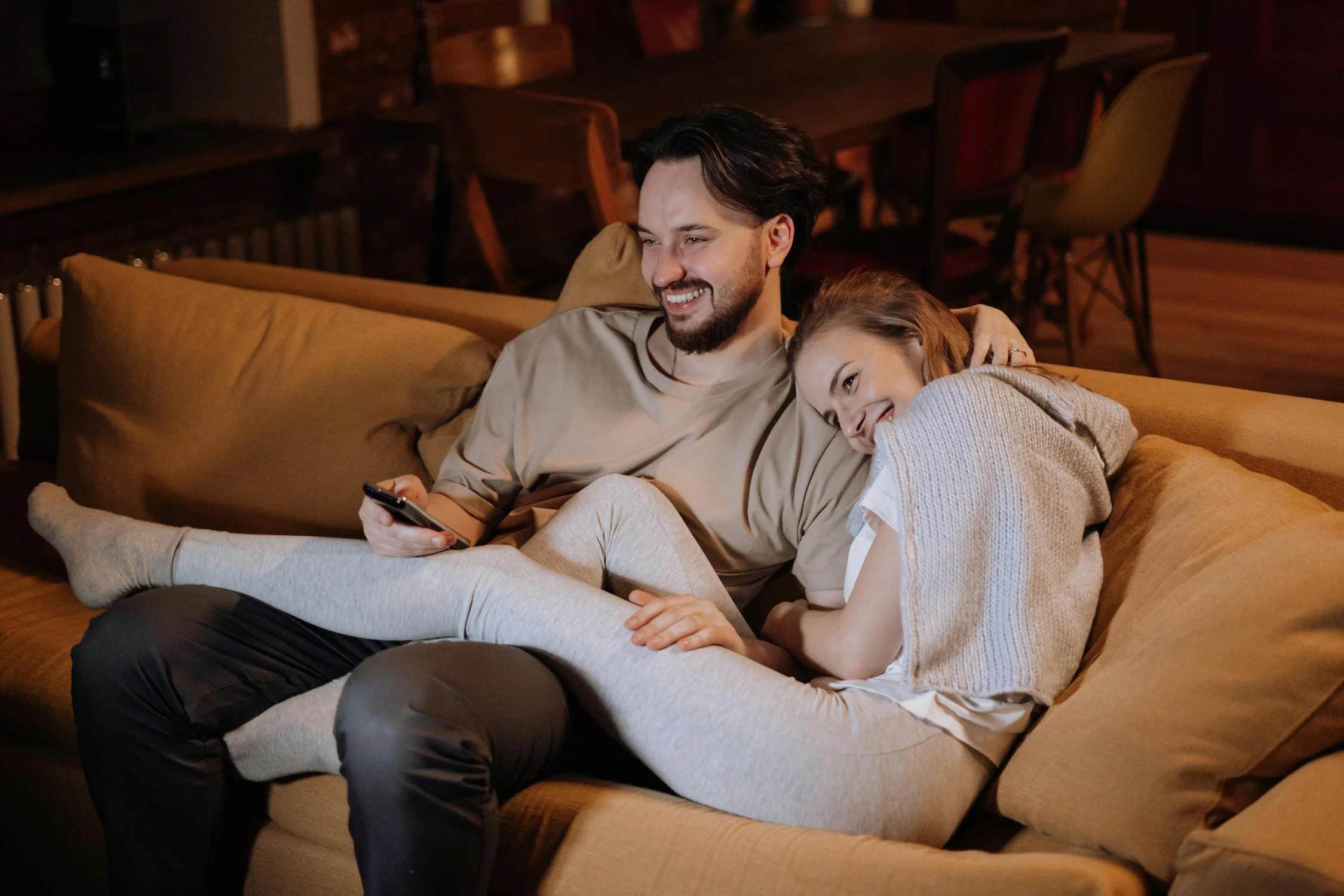 A happy couple on their couch | Source: Pexels