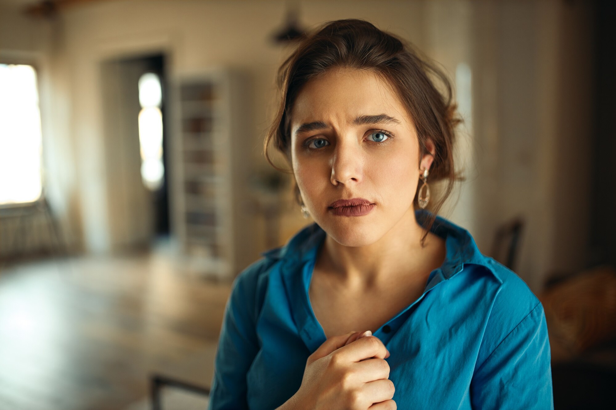 A sad woman in her apartment | Source: Freepik